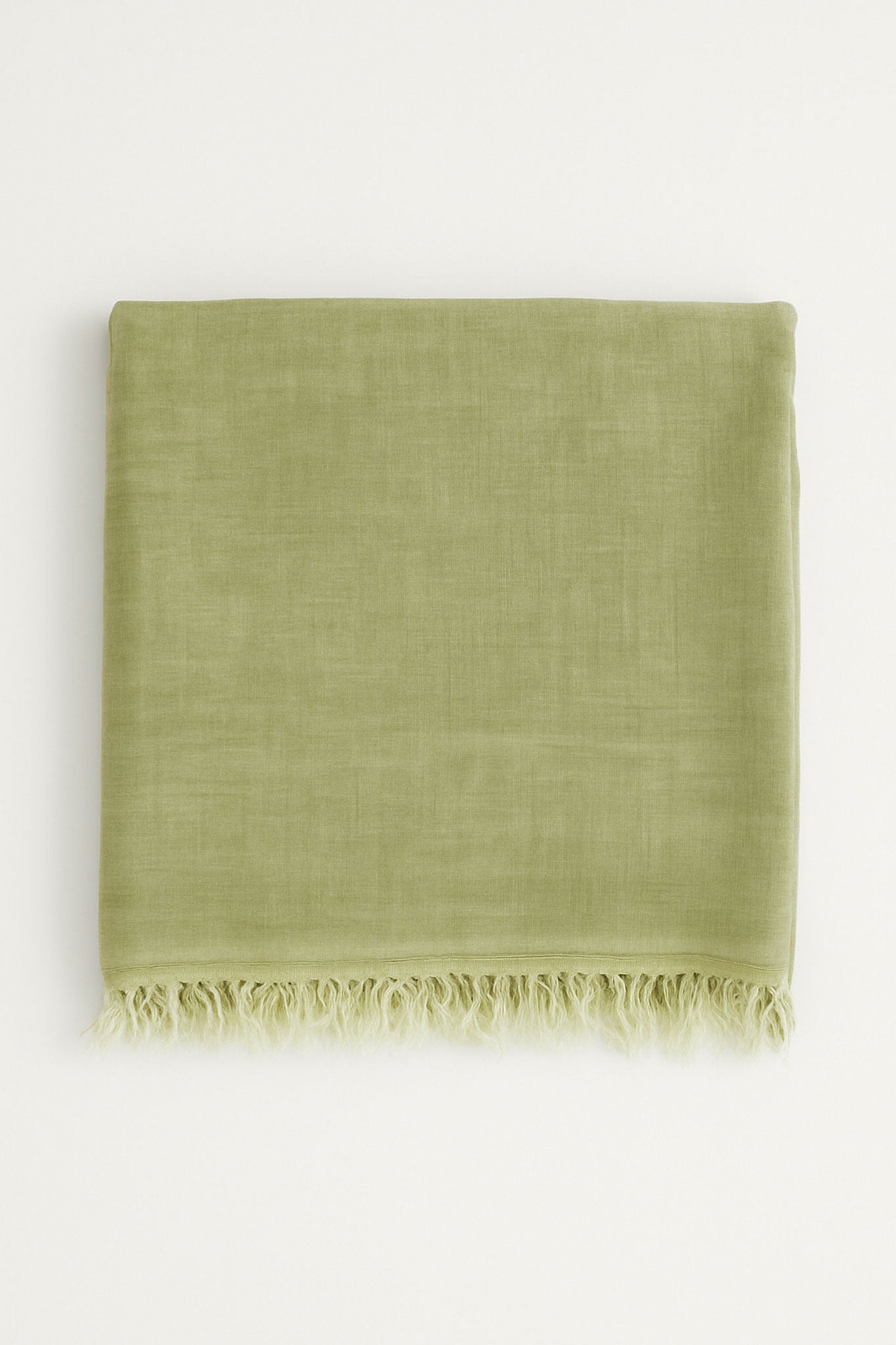 Détail d'une écharpe élégante vert olive en modal, laine et cachemire, idéale pour sublimer une tenue de soirée.