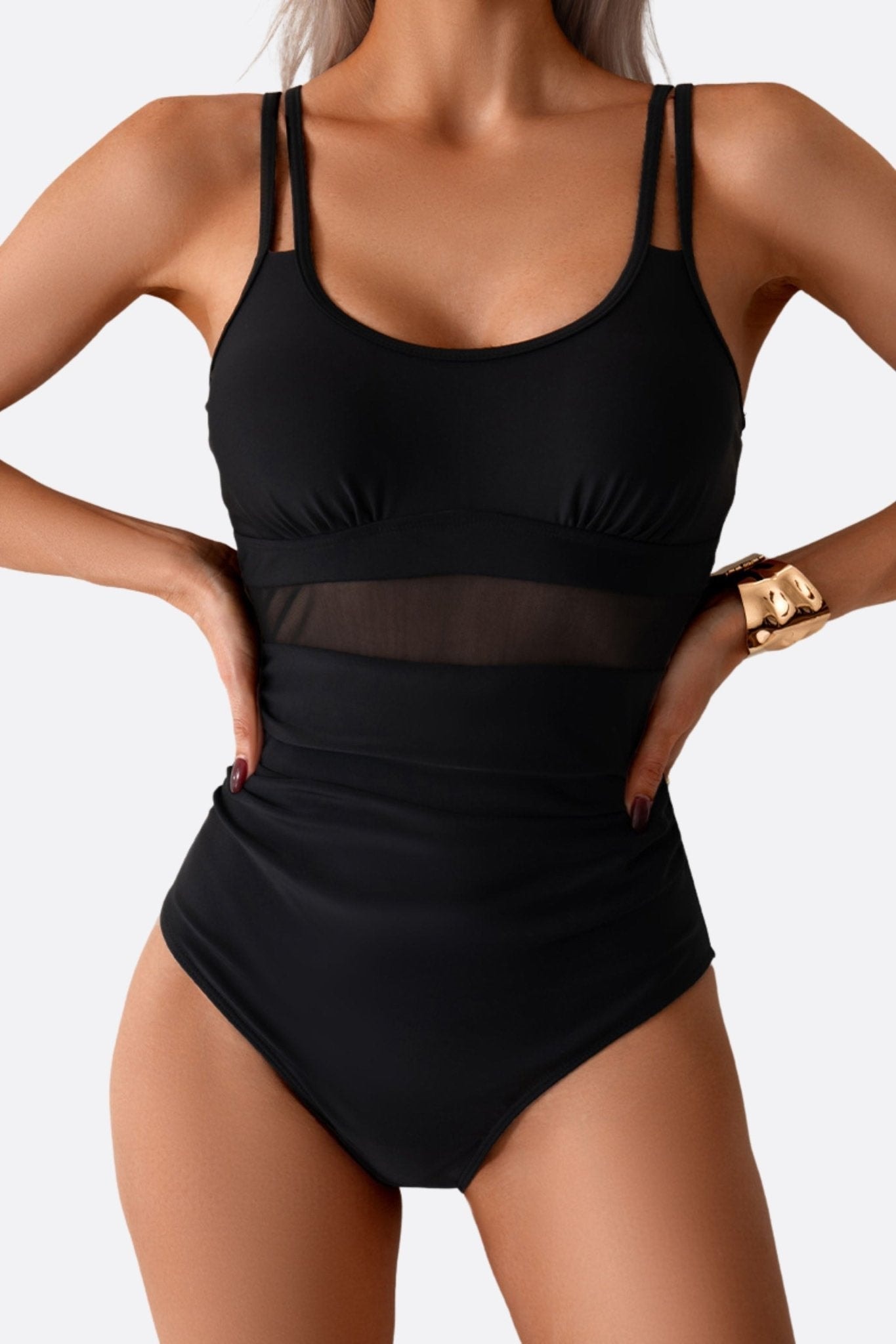 Zoom sur le maillot de bain noir en résille, un modèle chic et moderne pour des moments de détente au bord de la piscine.