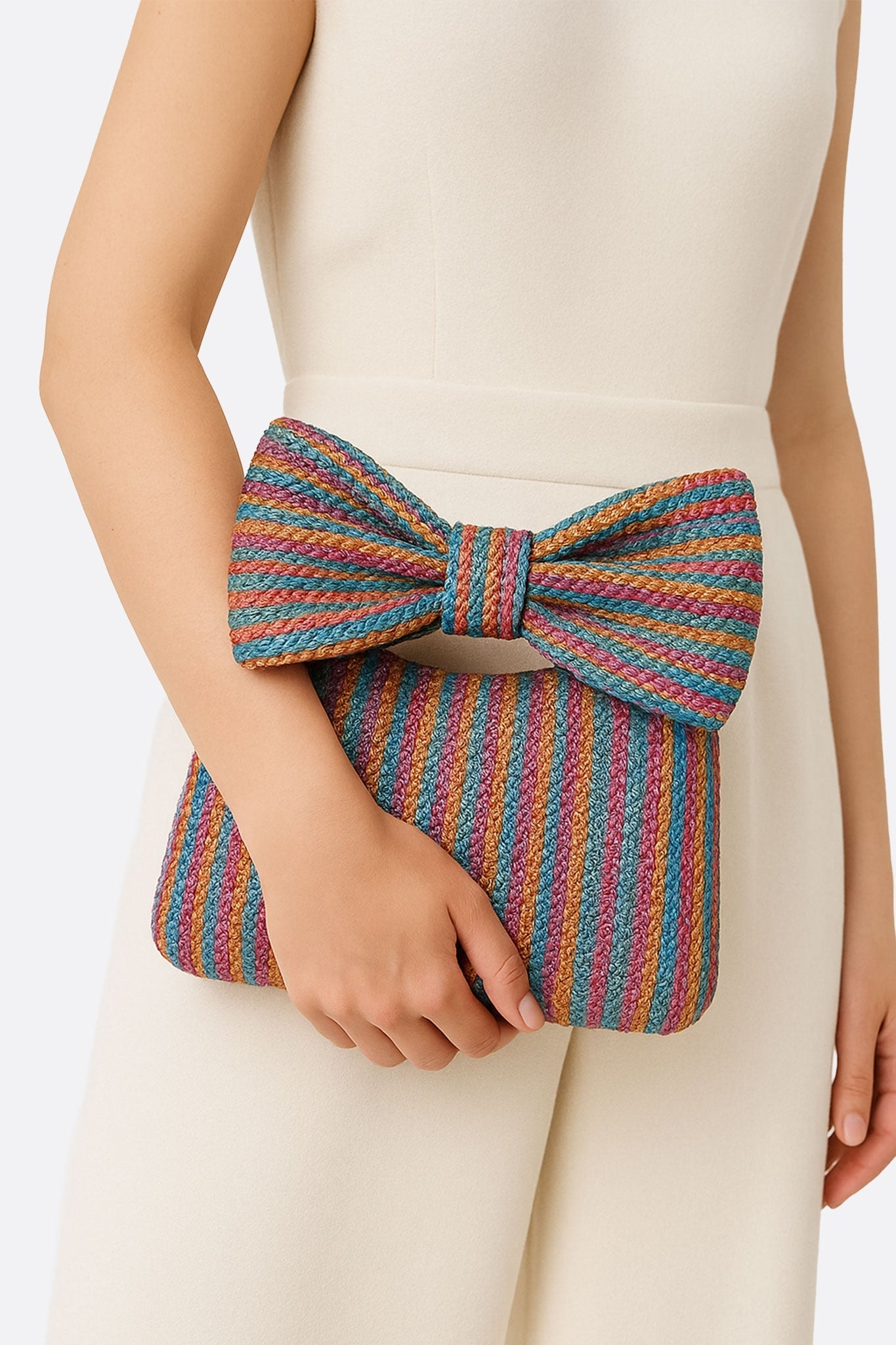 Nahaufnahme einer Tasche aus geflochtenem Stroh in schillernden Farben, verziert mit einer eleganten Schleife, ideal für einen Abend...