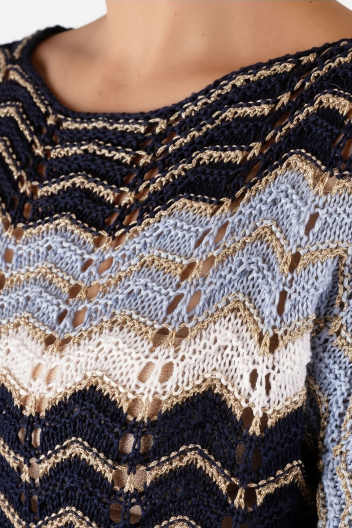 Detail of the blue and white openwork knit pullover with chevron pattern, an elegant choice for a refined office style.