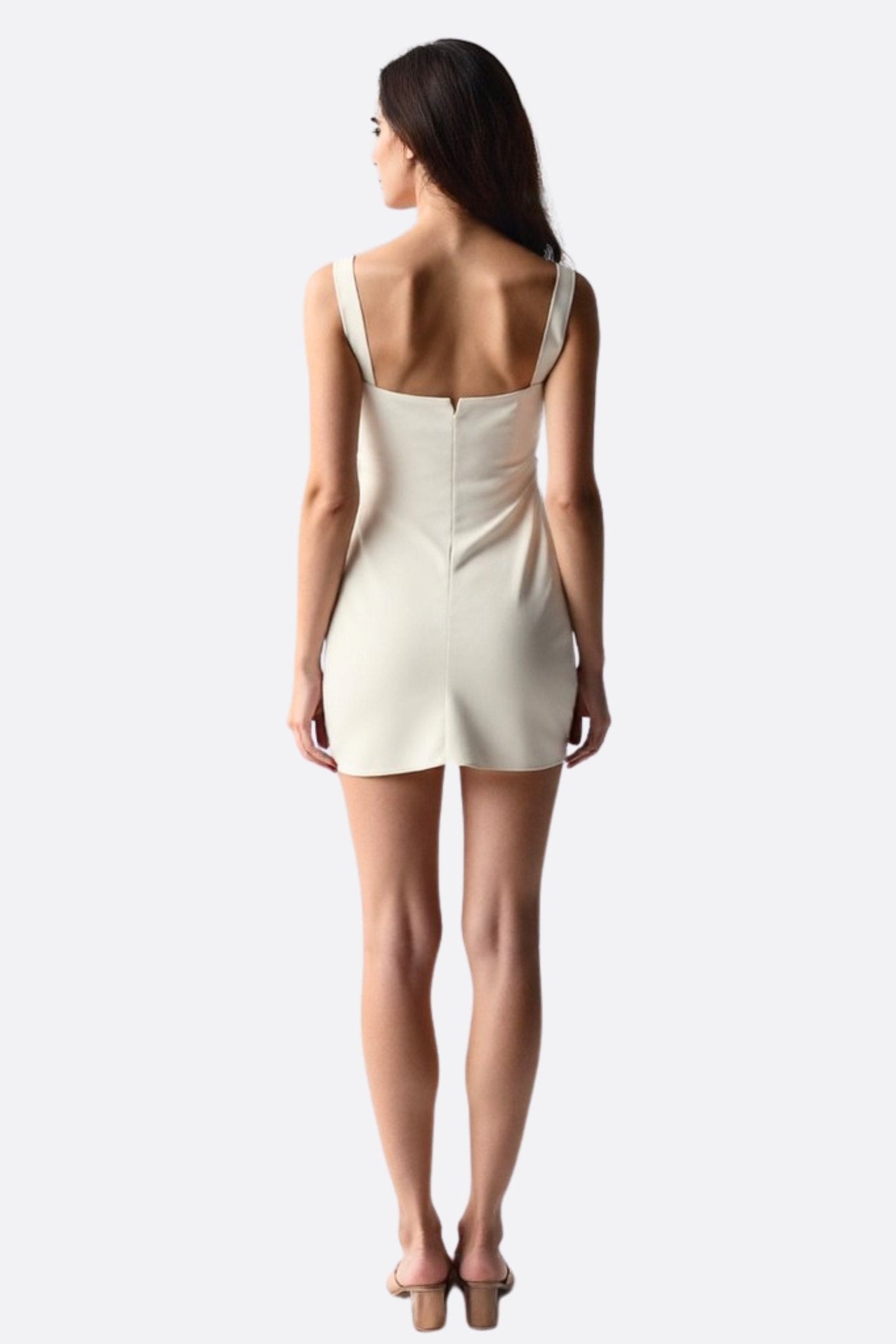 Primer plano de la textura sedosa del vestido corto marfil, revelando su aire chic y refinado para ocasiones especiales.