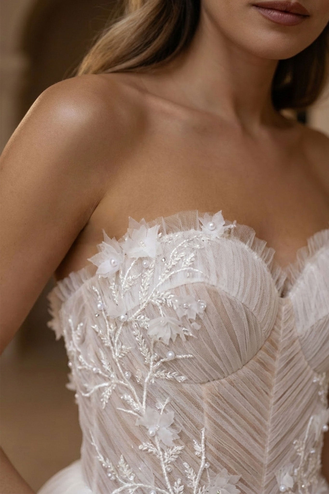 Dettaglio delicato dell'abito da sposa Alena, bustier in tulle bianco e sovrabito, per un allure romantico ed elegante.