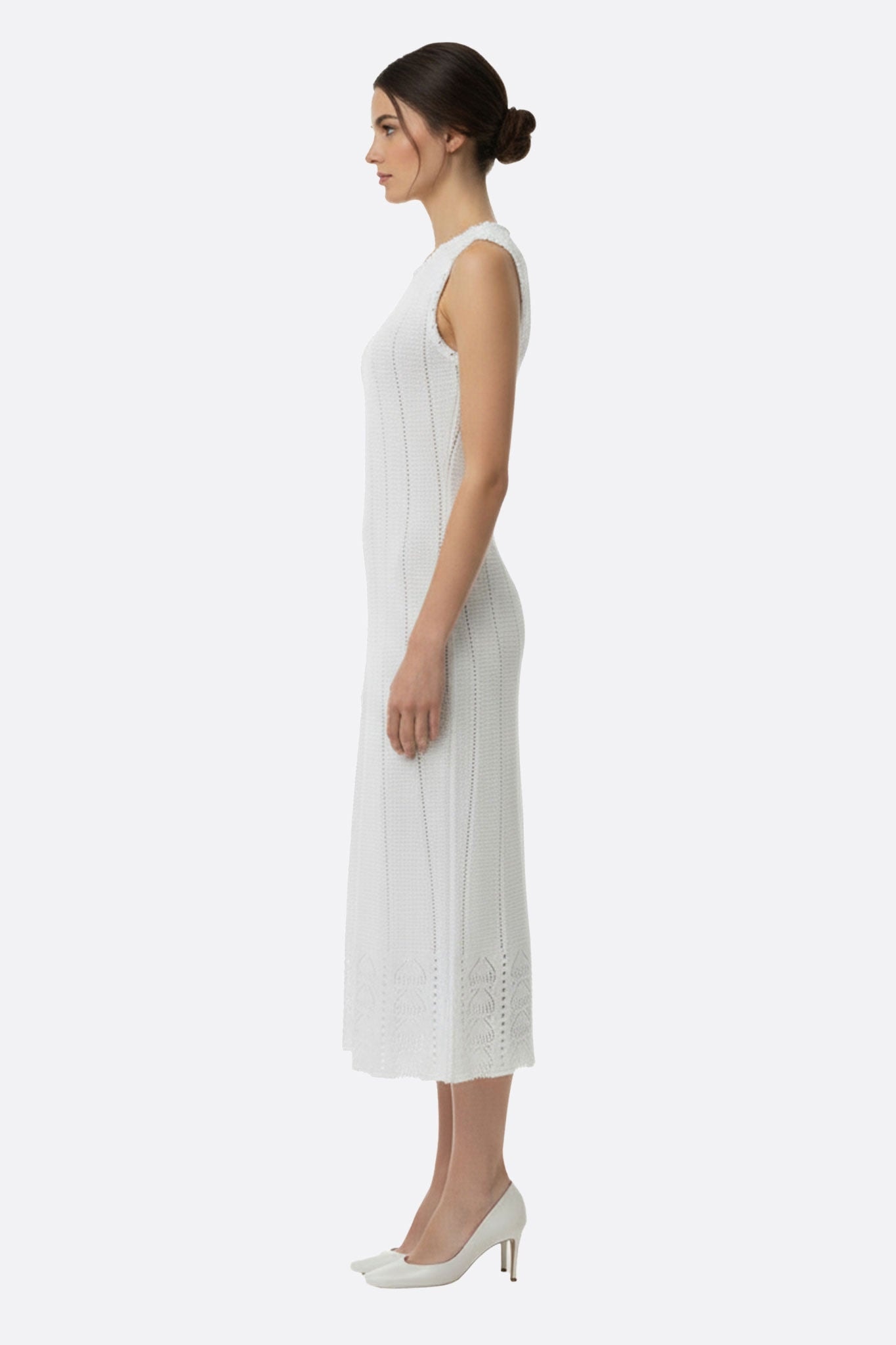 Zoom sur la robe longue blanche en maille perlée, mettant en avant son allure délicate pour des événements estivaux chics.