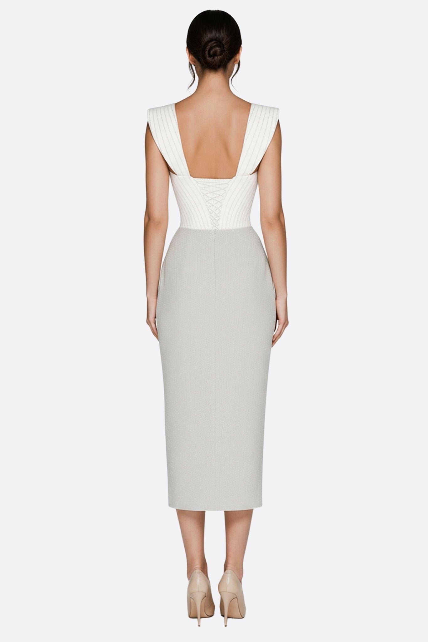 Detail of the white midi dress with openwork corset, highlighting its front slit for a glamorous evening silhouette.
