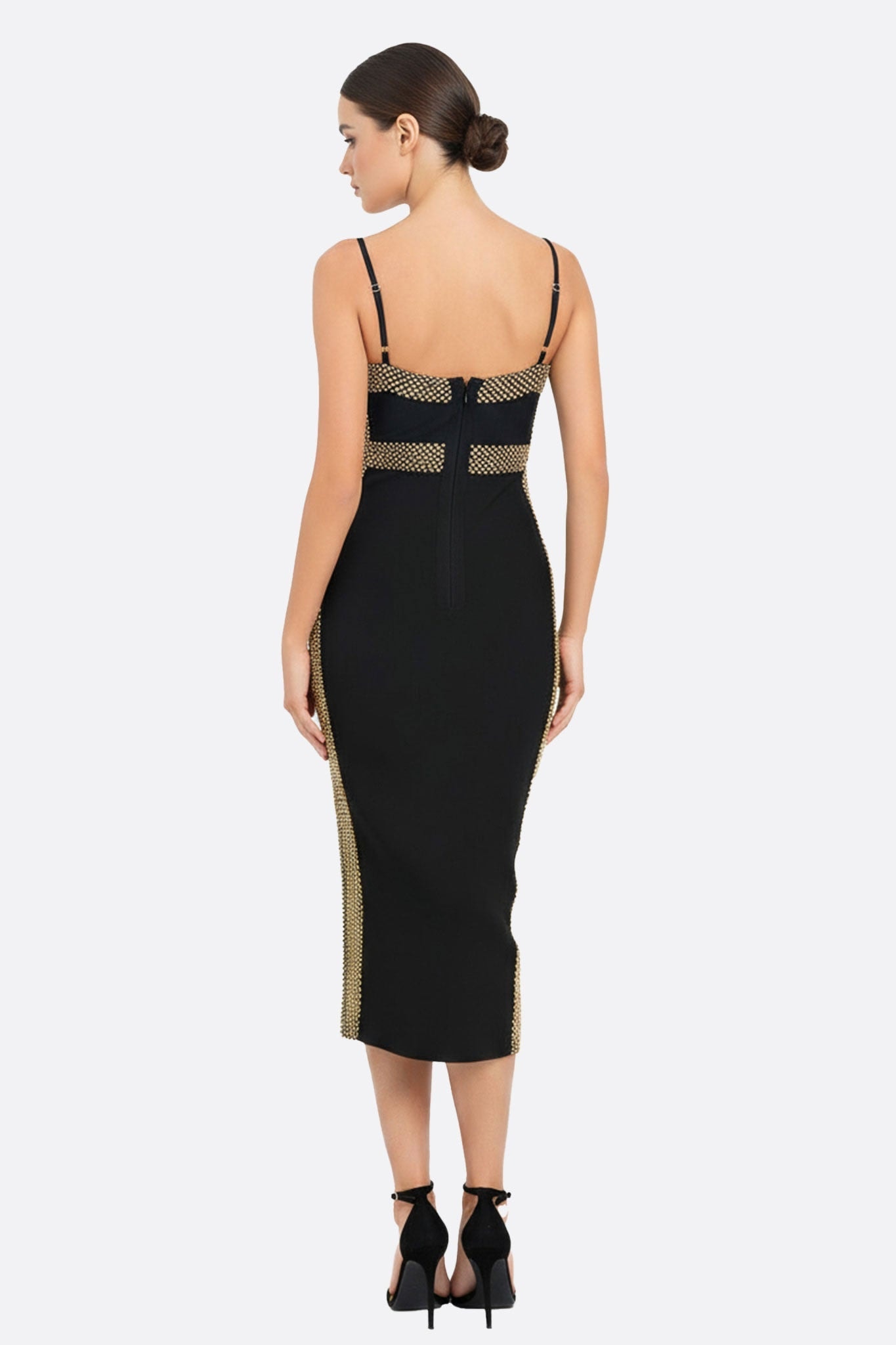 Détail captivant de la robe midi noire en maille sculptante, mettant en avant les délicats reflets dorés, pour un look chic.