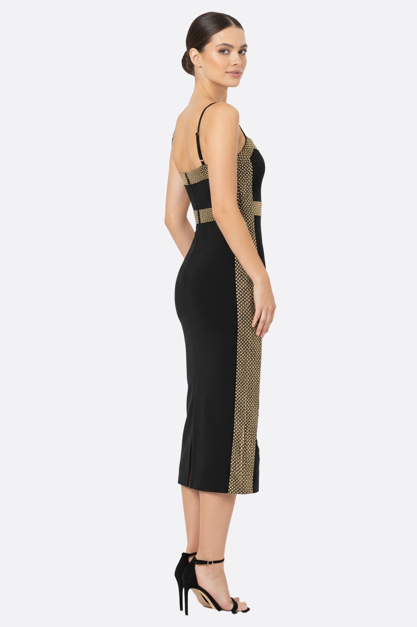 Zoom sur la texture de la maille sculptante dorée de la robe noire midi, révélant son élégance parfaite pour des...