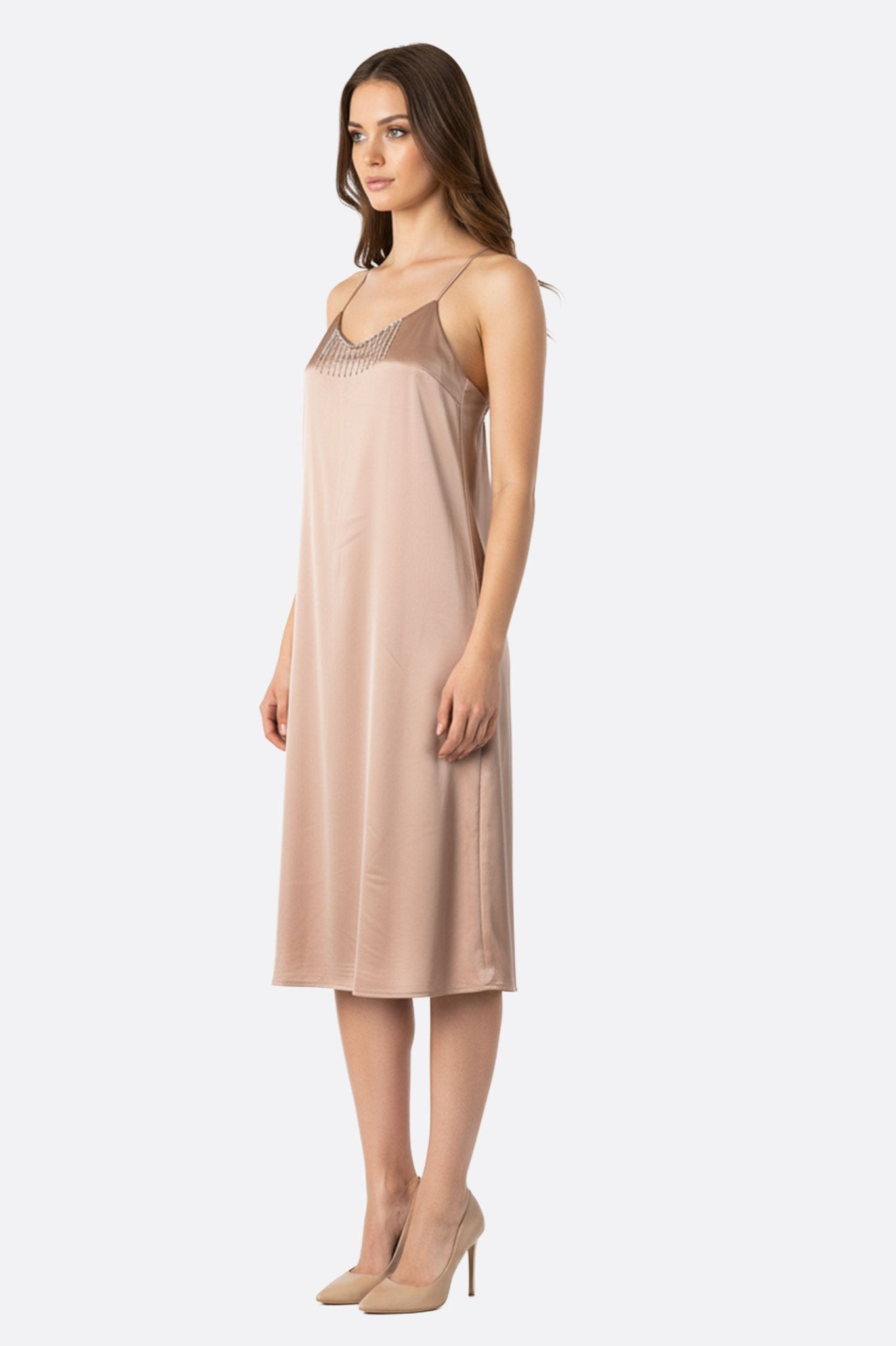 Close-up on the silver rhinestone chains of a rose beige satin dress, ideal for a glamorous event or an evening out.