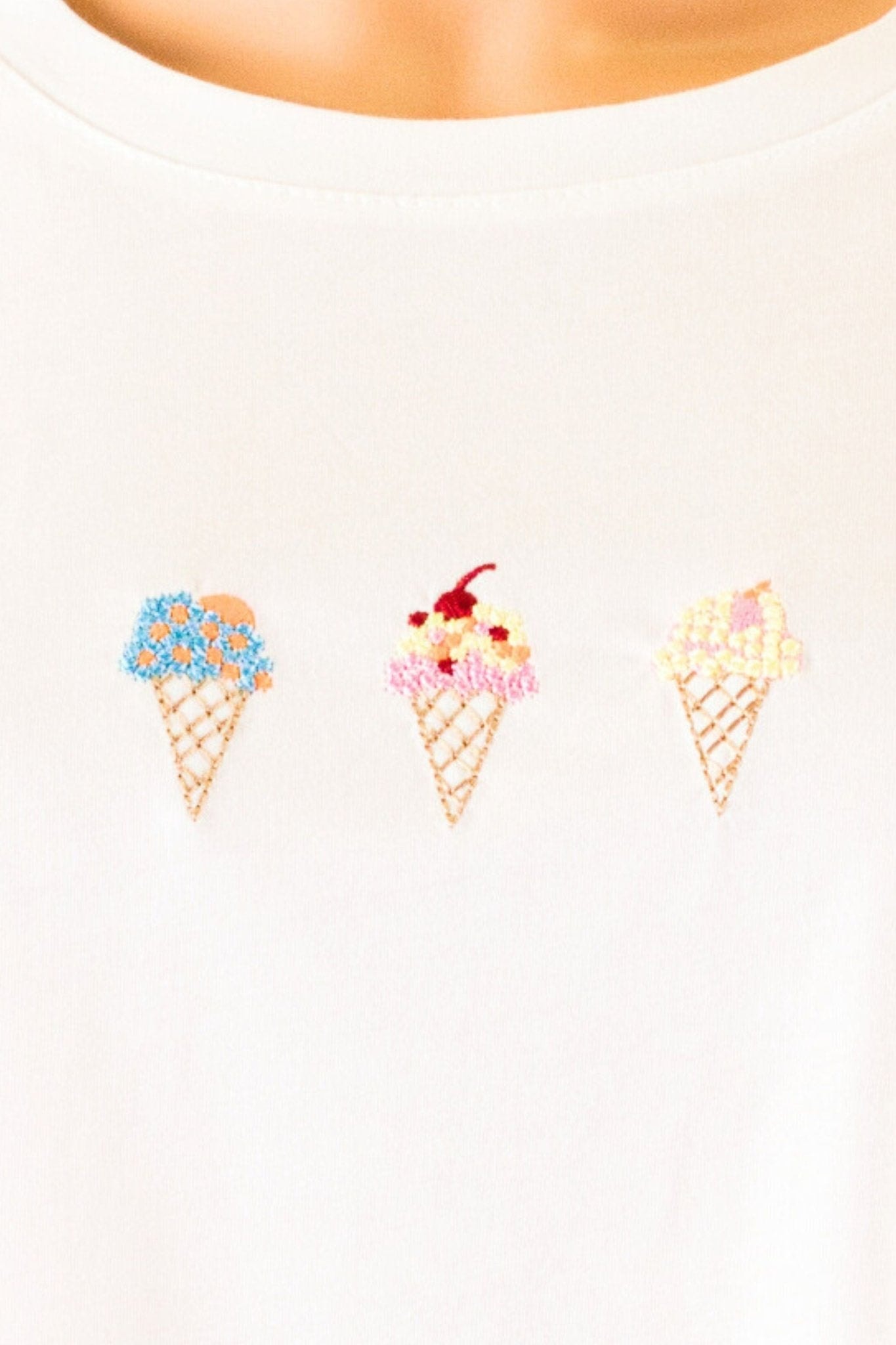 Dettaglio della texture morbida e del ricamo delicato della t-shirt bianca oversize Gelato, perfetta per uno stile quotidiano...