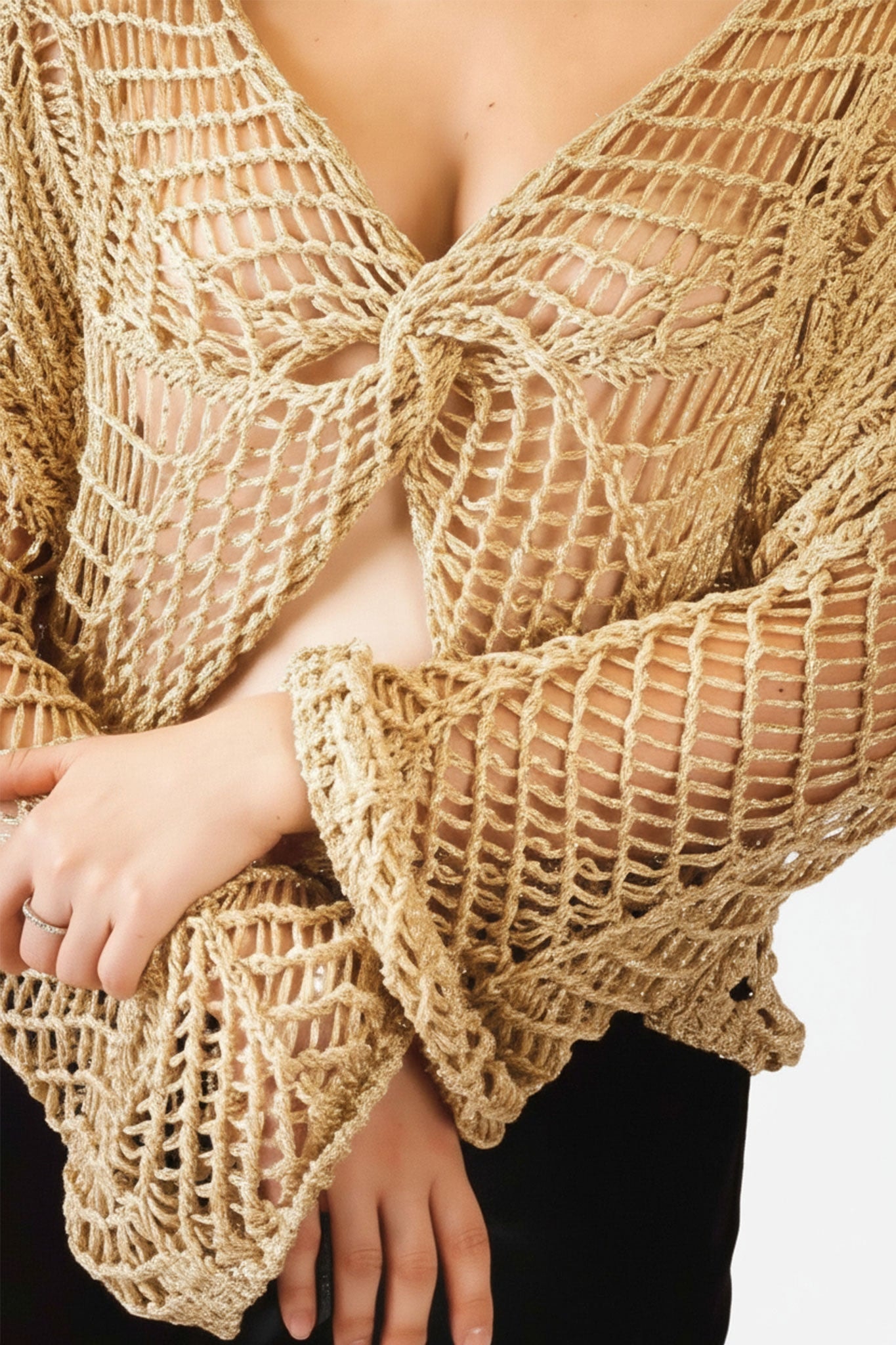 Détail du haut en maille crochet ajourée beige, mettant en avant sa texture aérée et son élégance pour un style estival.