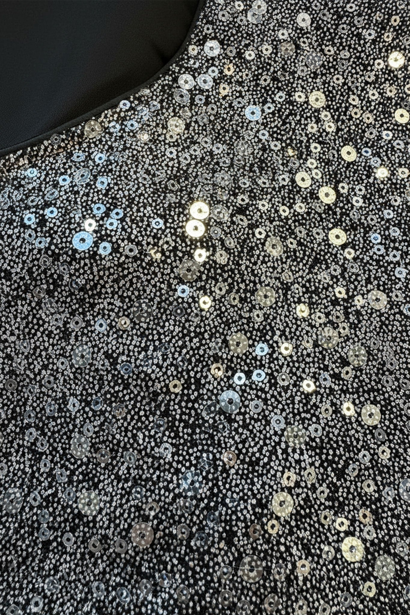 Black top with silver sequins catching the light, highlighting the pleated cuffs, perfect for an elegant evening.