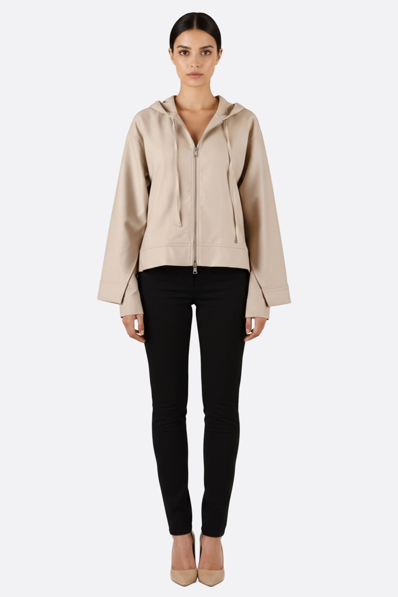 Dettaglio della giacca beige con cappuccio in cotone, che ne evidenzia la texture moderna e lo stile casual per le uscite.