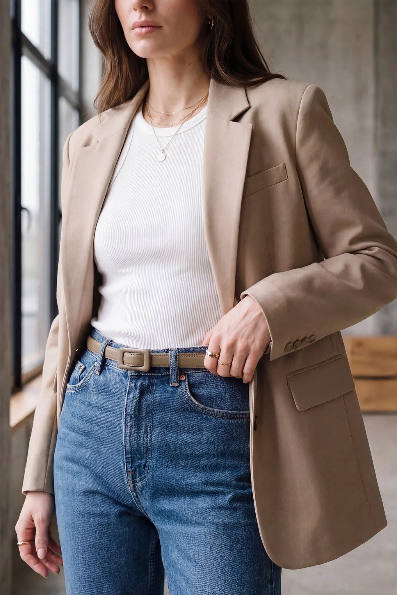 Detalle del cinturón fino topo, hebilla rectangular forrada, accesorio perfecto para un look refinado de noche.