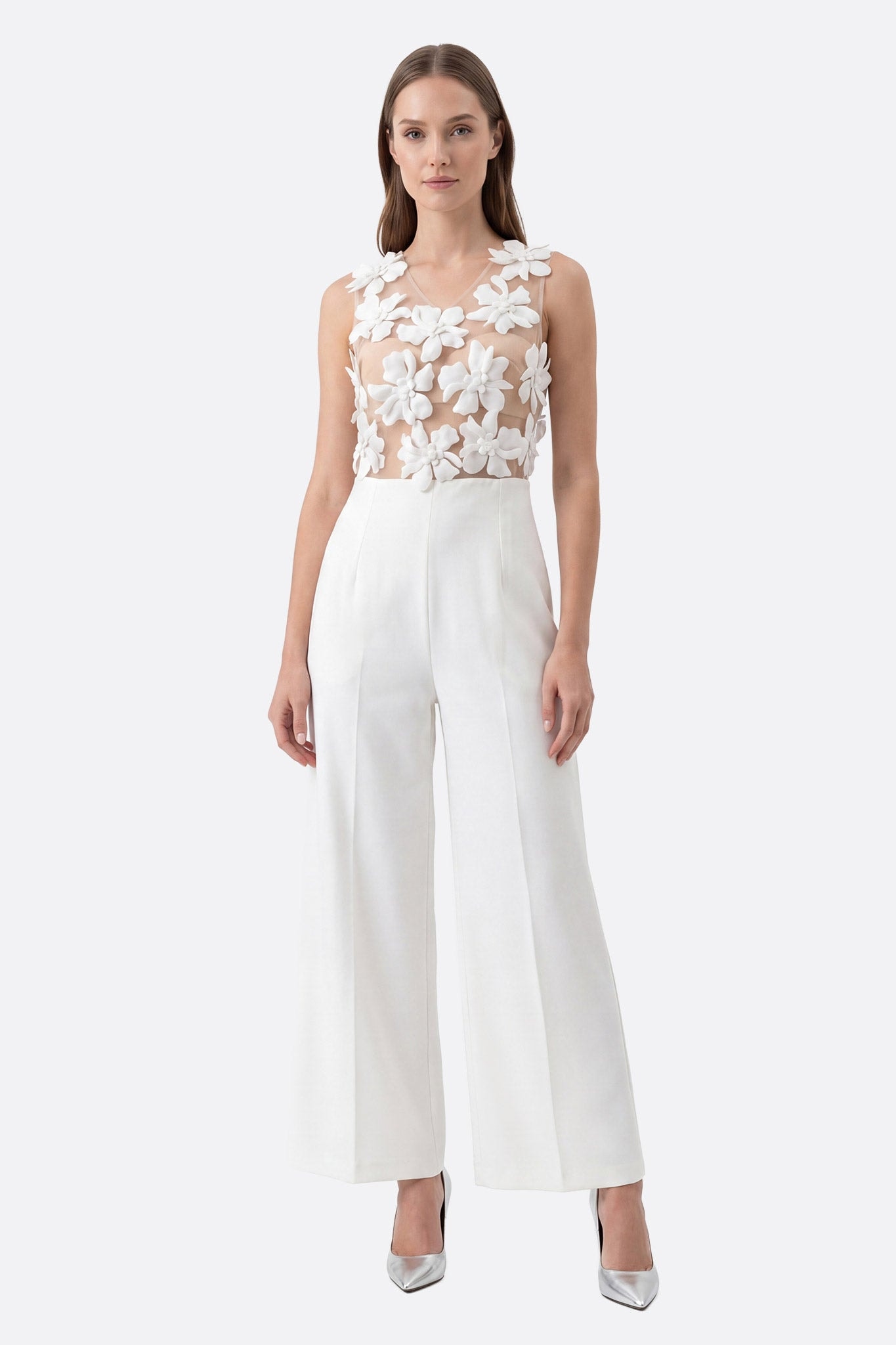 Mannequin de face portant une combinaison blanche coupe large avec haut transparent à fleurs 3D