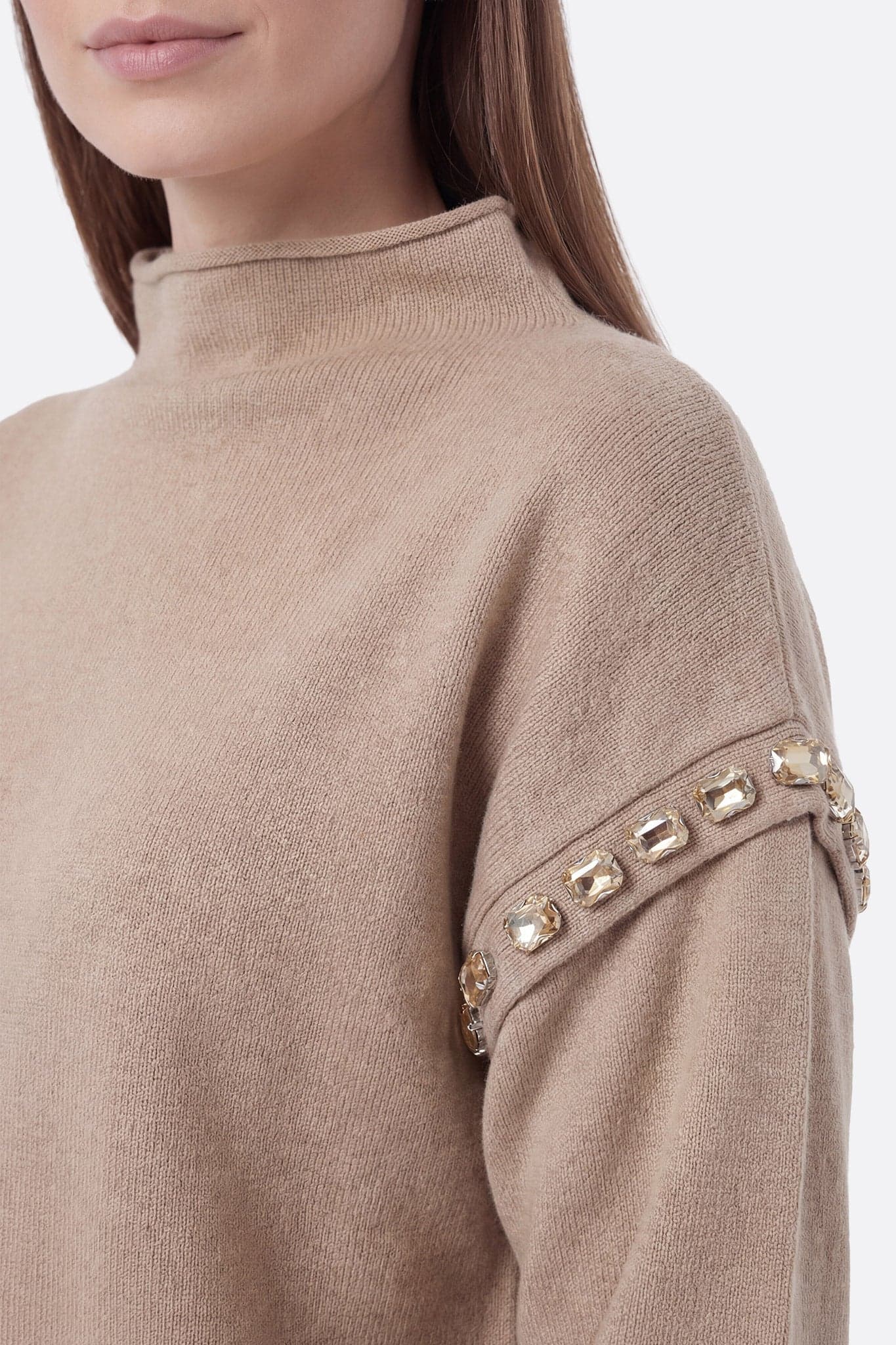 Close-up on the decorative details of the beige knit set, with structured long skirt and soft sweater, ideal for the...