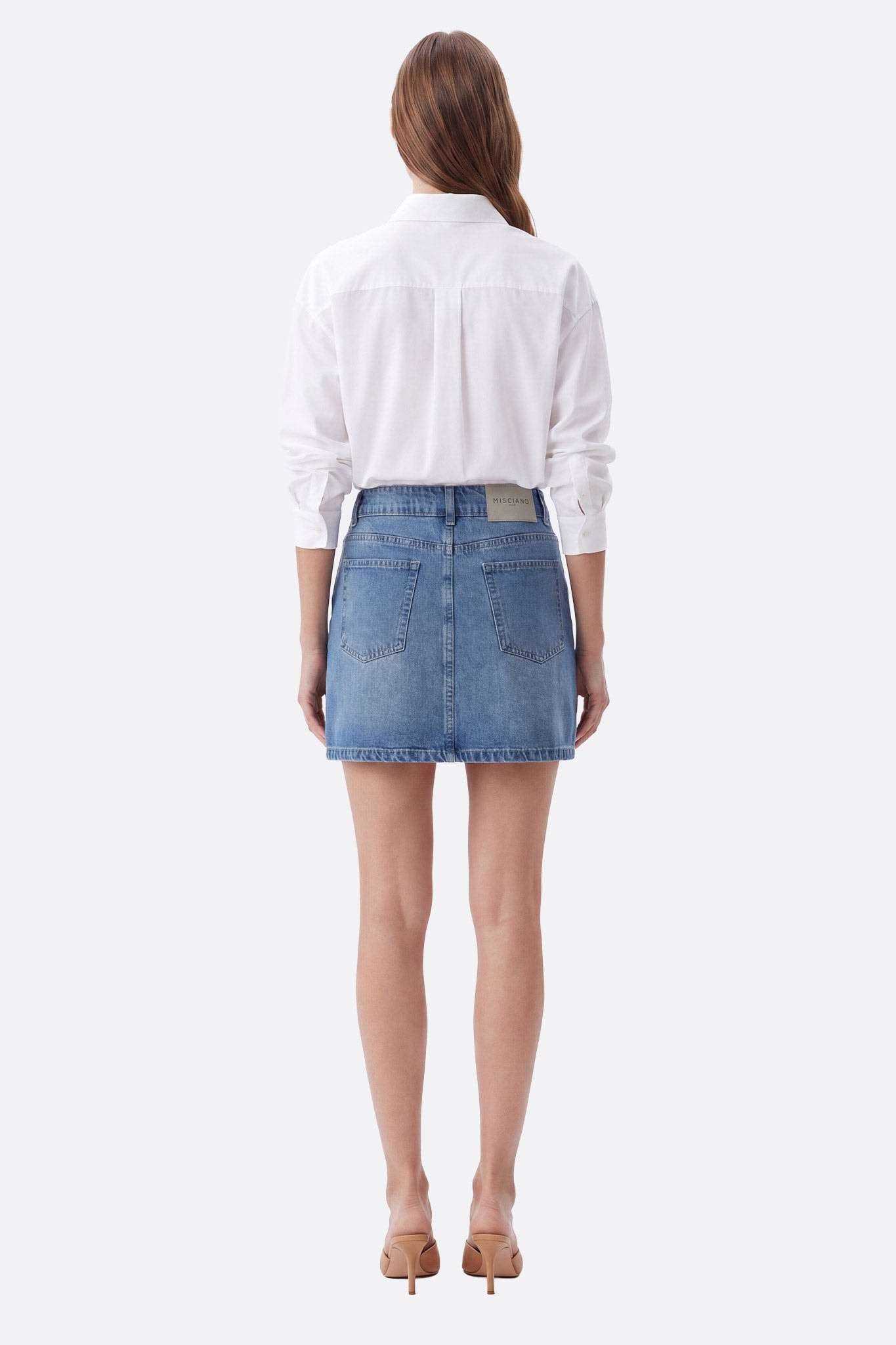Mannequin de dos portant une jupe courte denim en coton coupe droite avec poches plaquées
