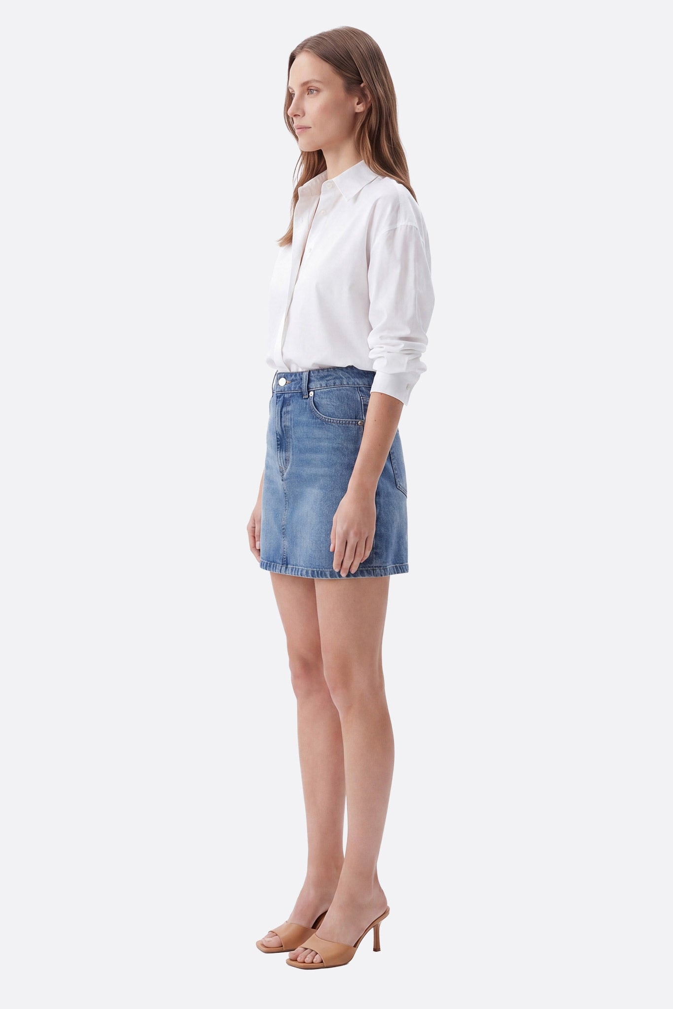 Jupe courte denim en coton coupe droite portée de profil par une femme