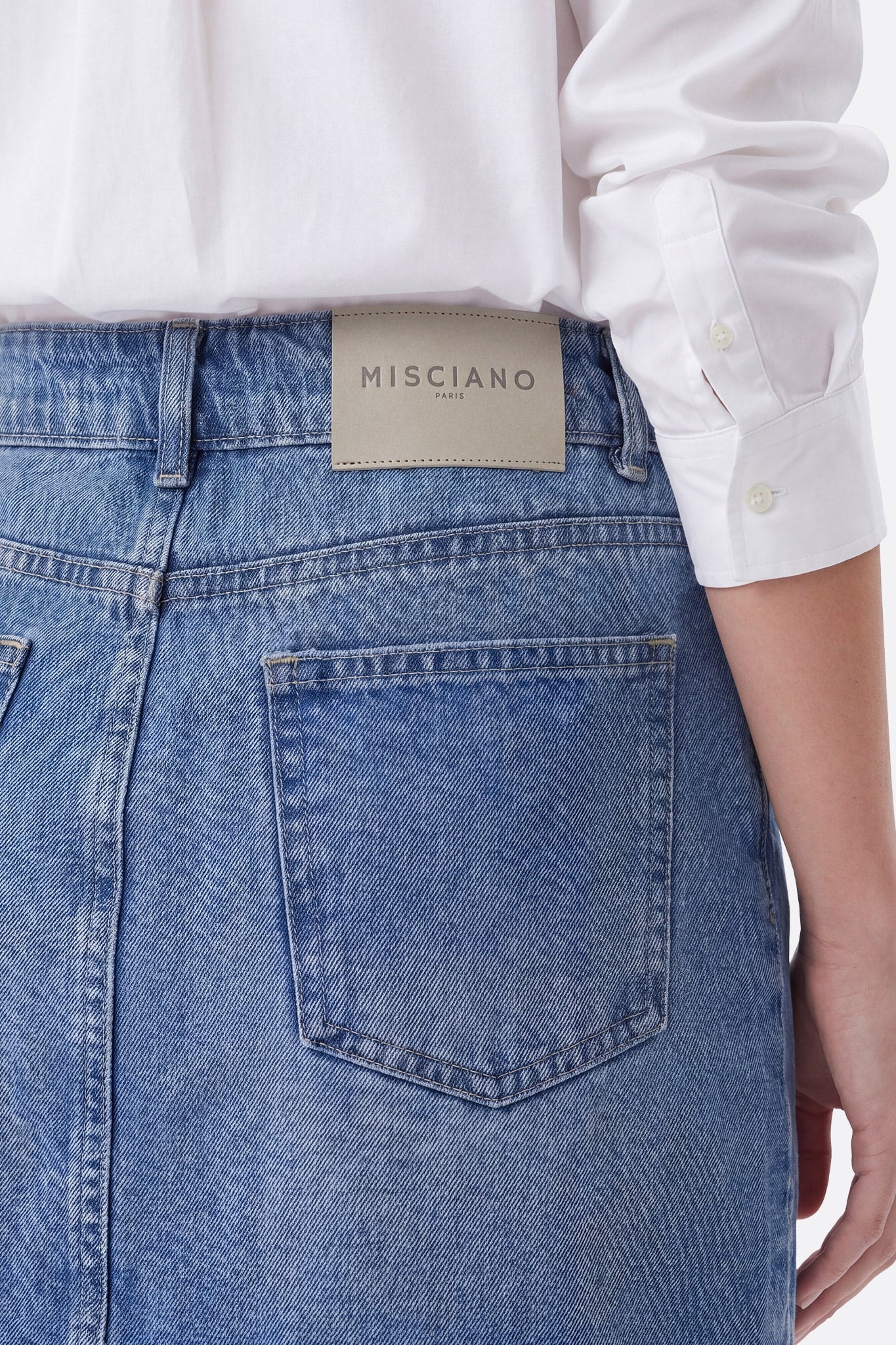 Jupe courte denim en coton coupe droite portée de dos, zoom sur l'étiquette et la poche arrière