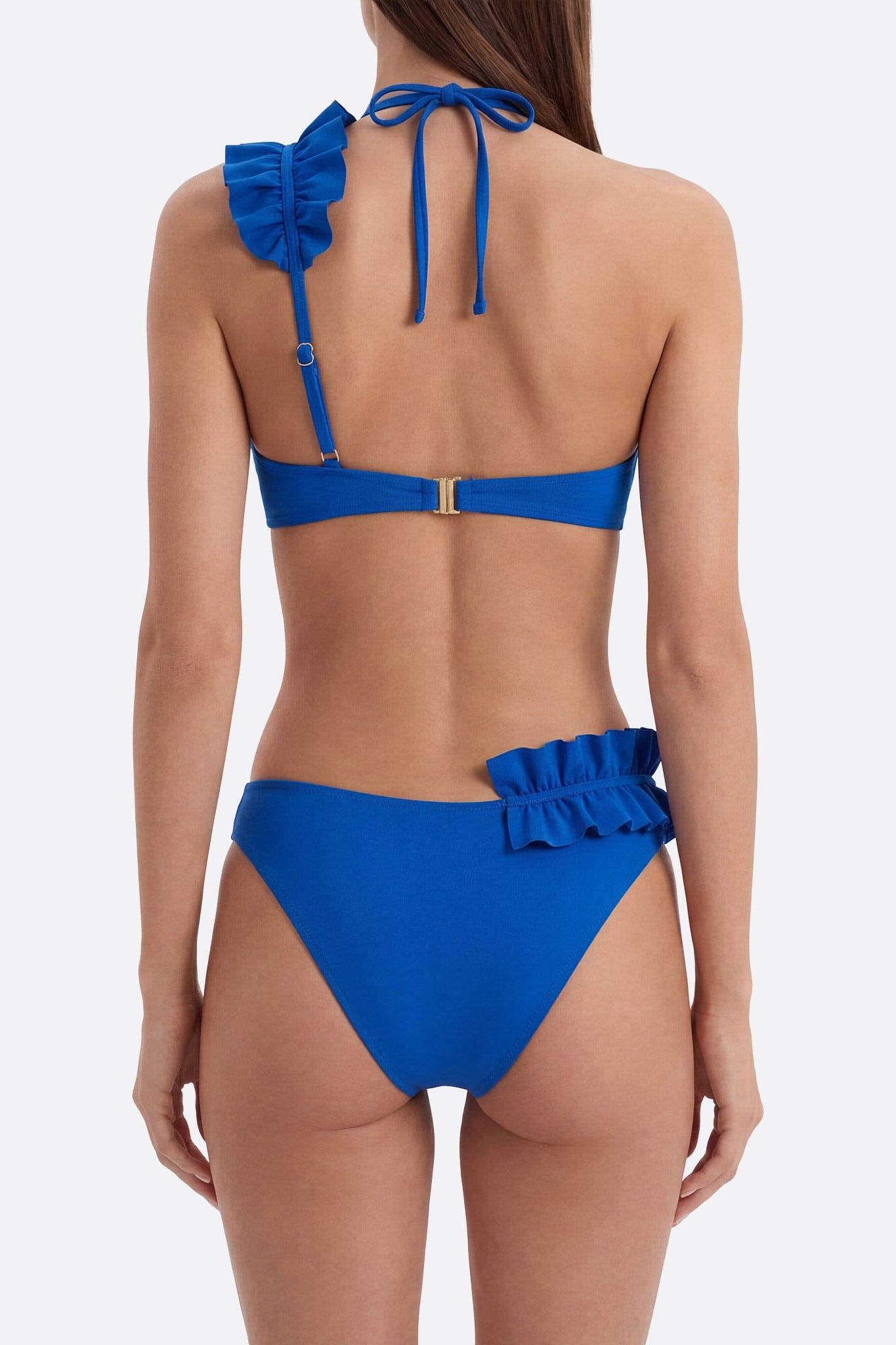 Faszinierendes Detail der Rüschen des marineblauen Bikinis, perfekt für raffinierte Momente im Strandurlaub.