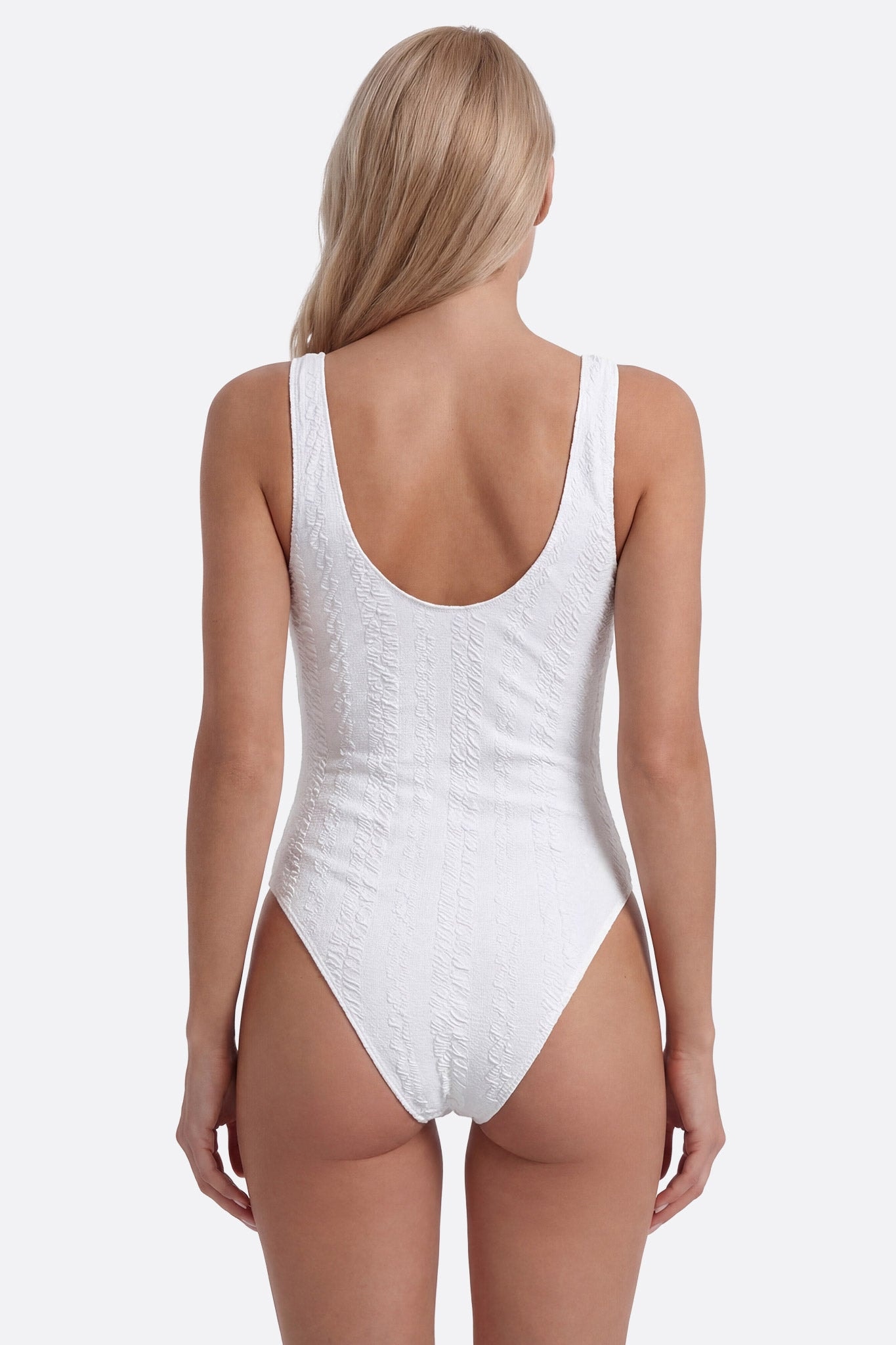 Dettaglio del costume intero bianco texture, scollo a U, ideale per un look elegante al mare
