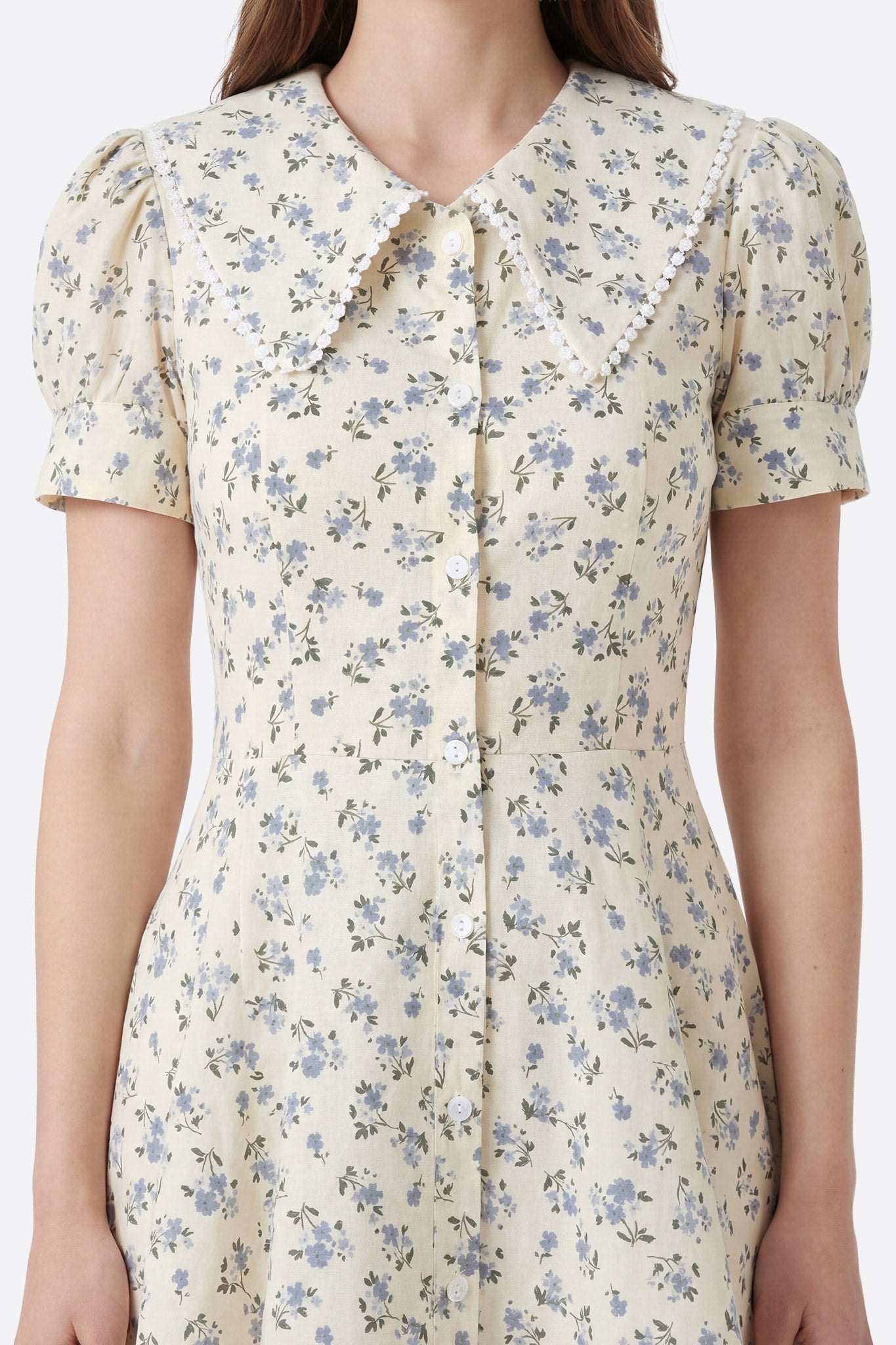 Vestido corto floral de algodón con cuello claudine, visto de frente, primer plano del cuello y los botones