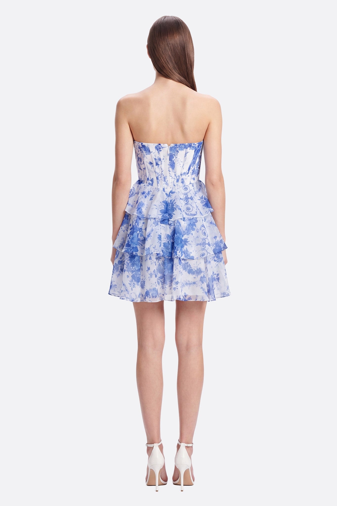 Abito corto bustier a volant con stampa blu visto da dietro su modella, zip visibile