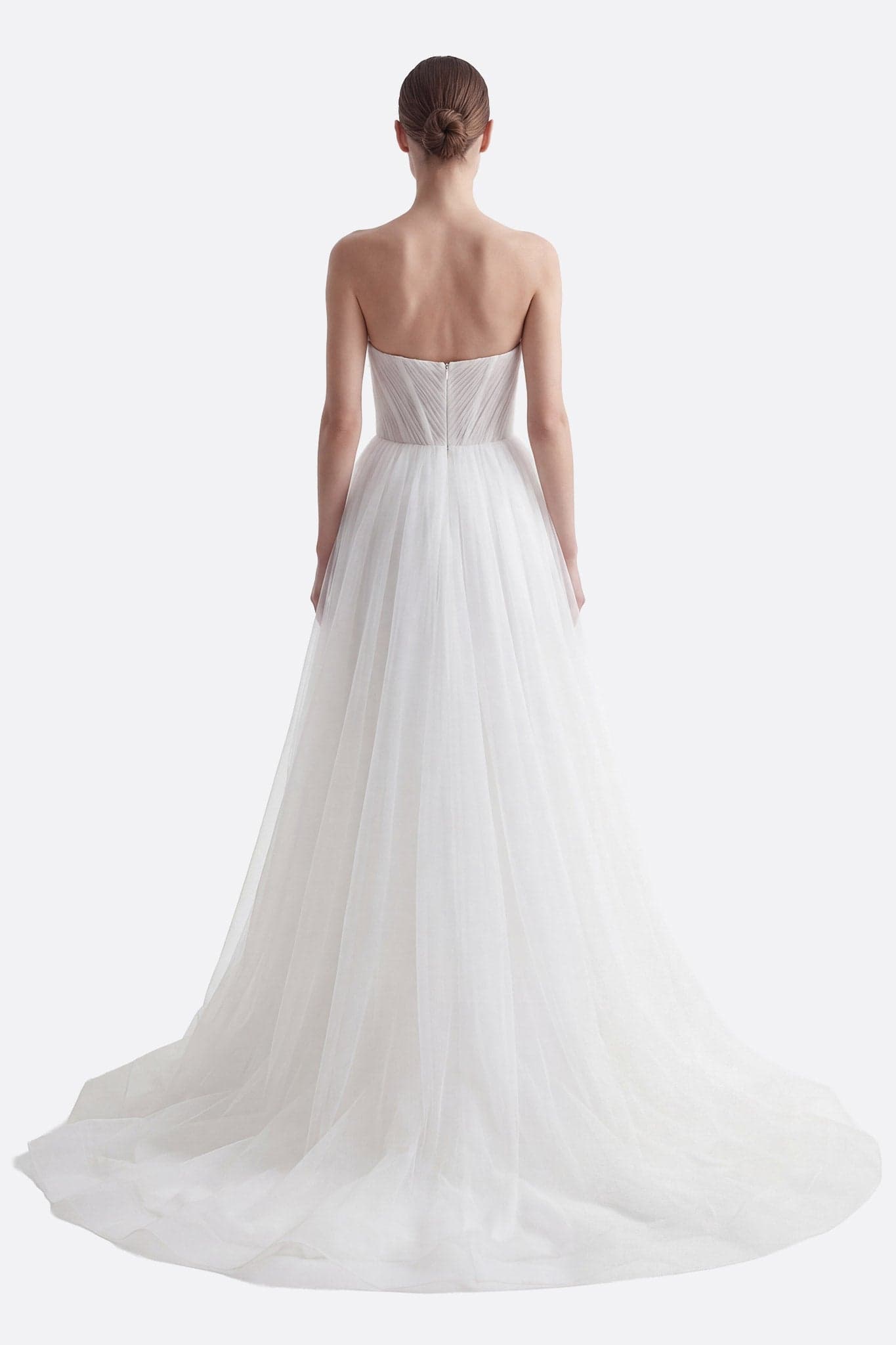 Vista laterale dell'abito da sposa in tulle, evidenziando il bustier ricamato, la gonna con spacco e la cappa rimovibile.