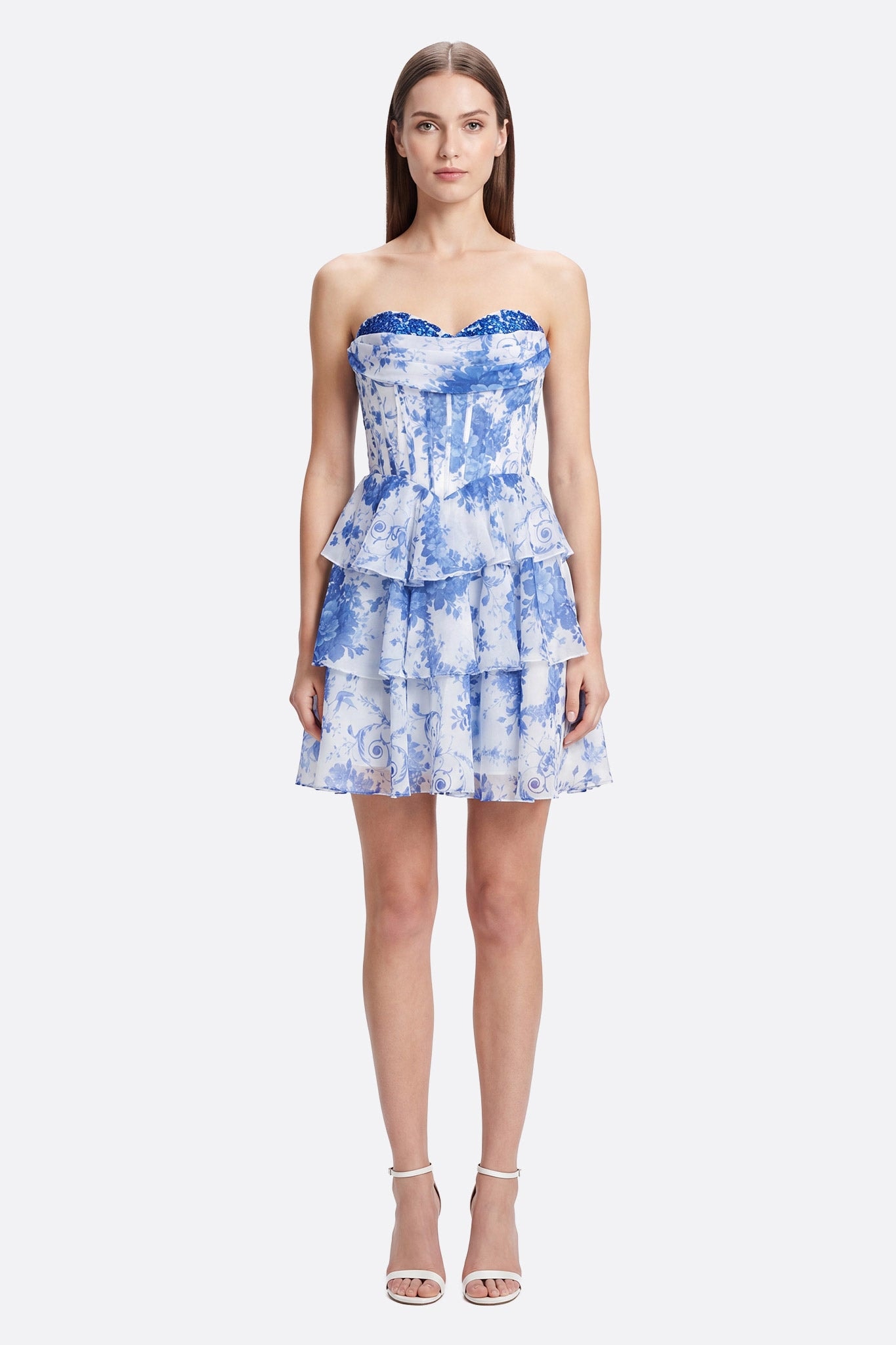 Modella frontale in abito corto bustier a volant con stampa floreale blu e bianco