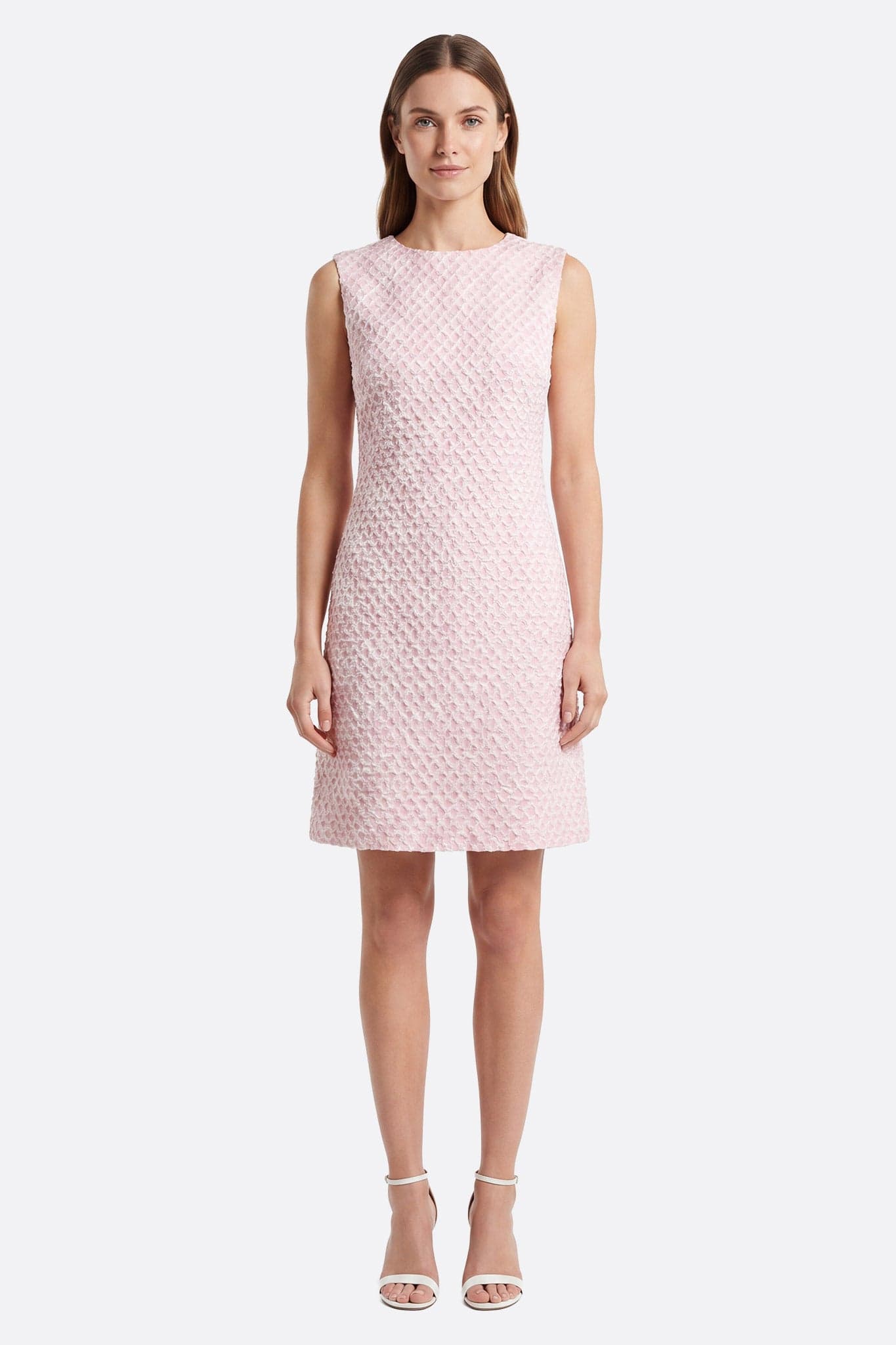 Abito corto rosa a texture goffrata indossato frontalmente da una donna, senza maniche e scollo rotondo