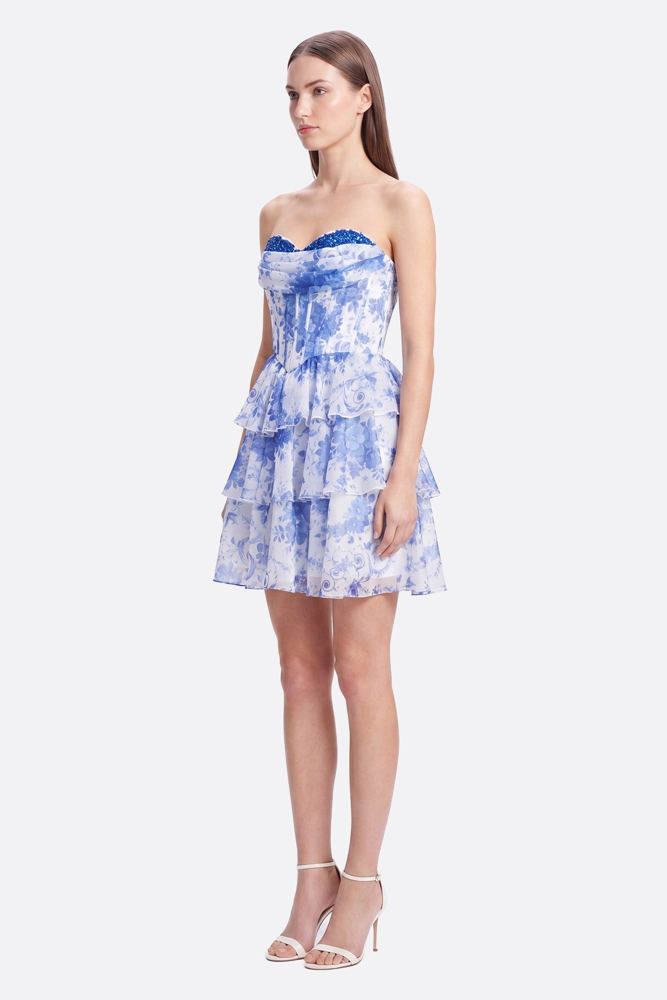 Modella frontale in abito corto bustier a volant con stampa floreale blu e bianco