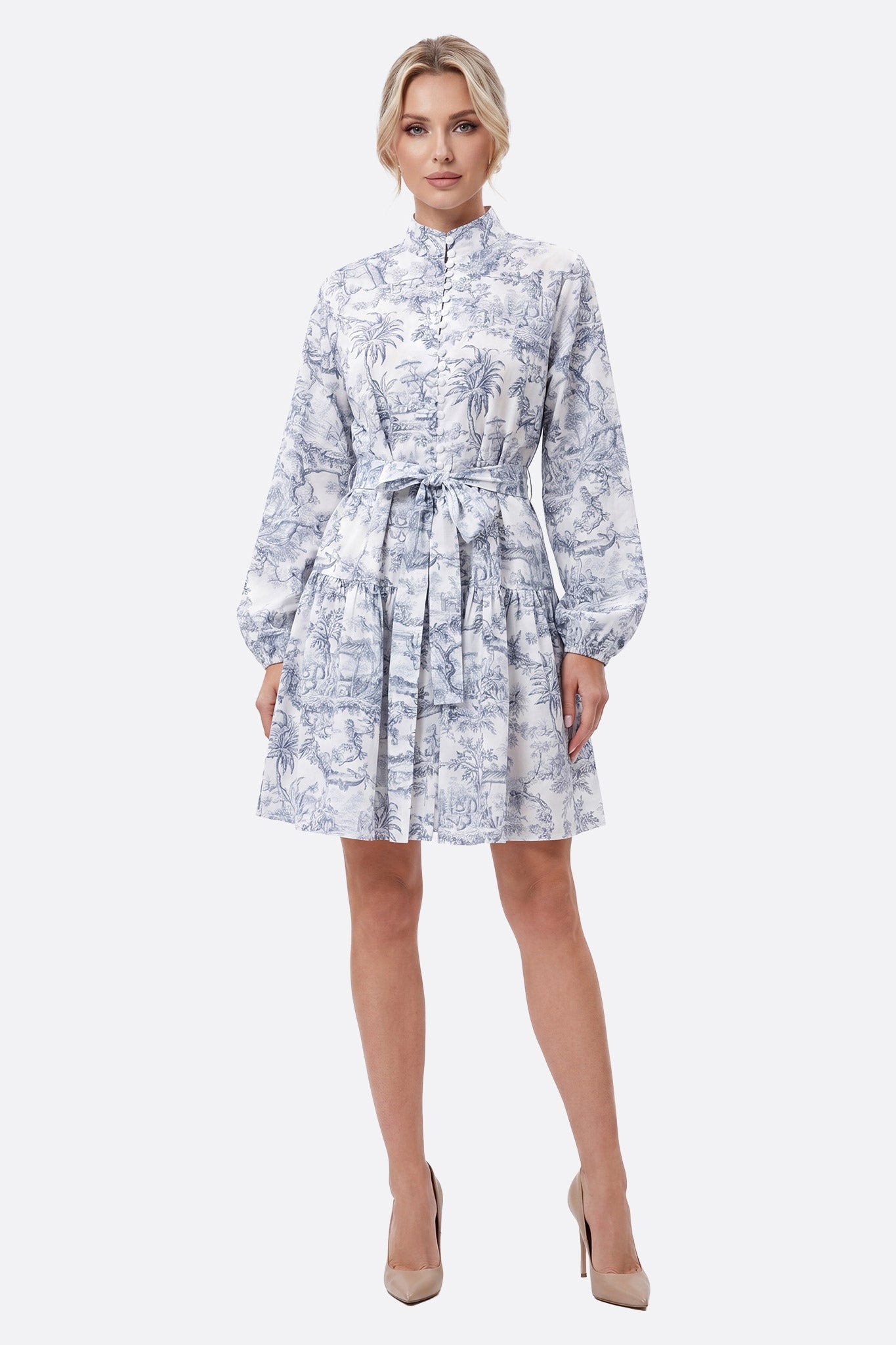 Frontales Model in einem kurzen Toile-de-Jouy-Kleid mit Taillengürtel, Stehkragen und Knöpfen