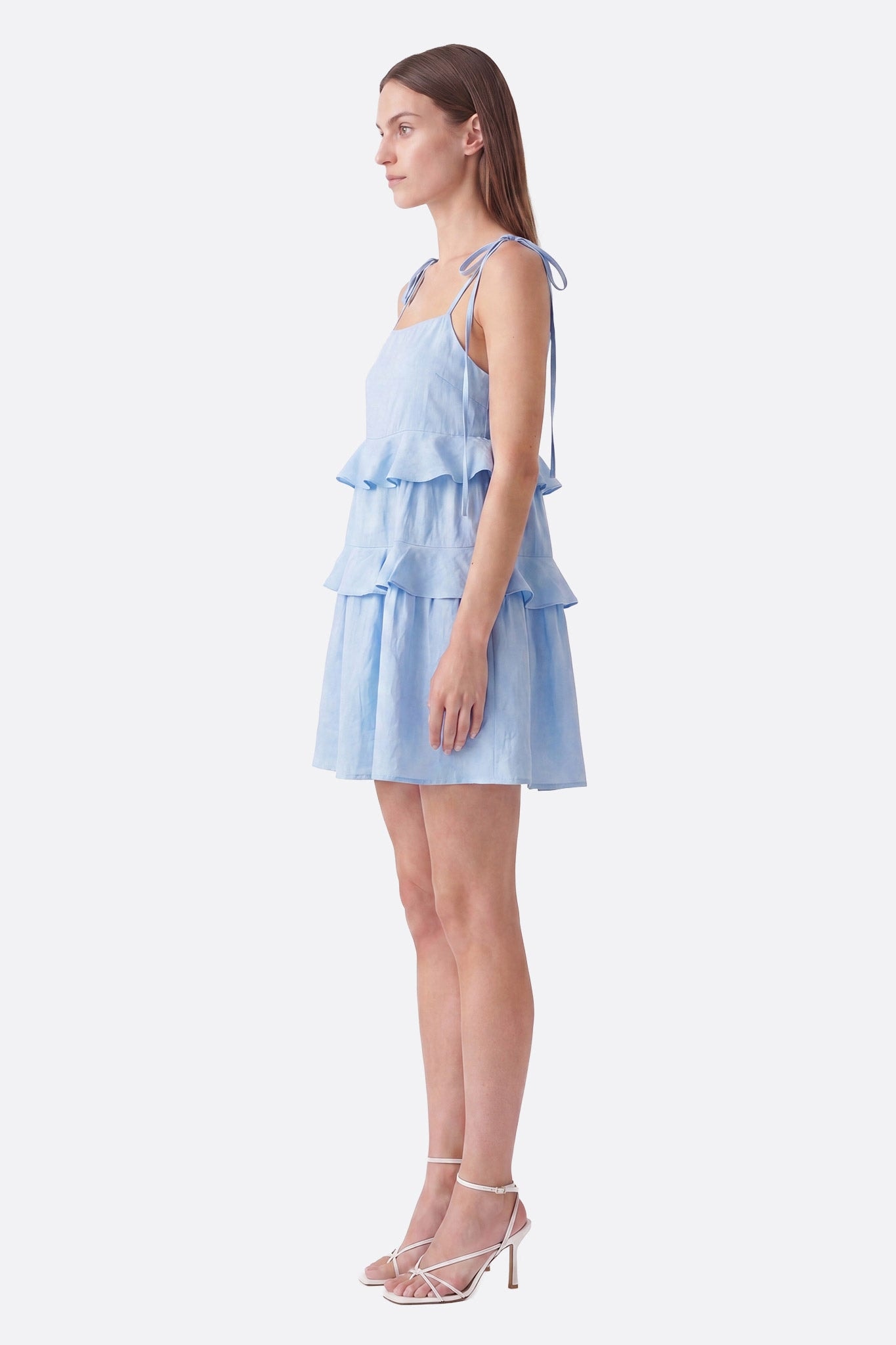 Hellblaues kurzes Kleid mit Volants im Profil am Model, gebundene Träger sichtbar