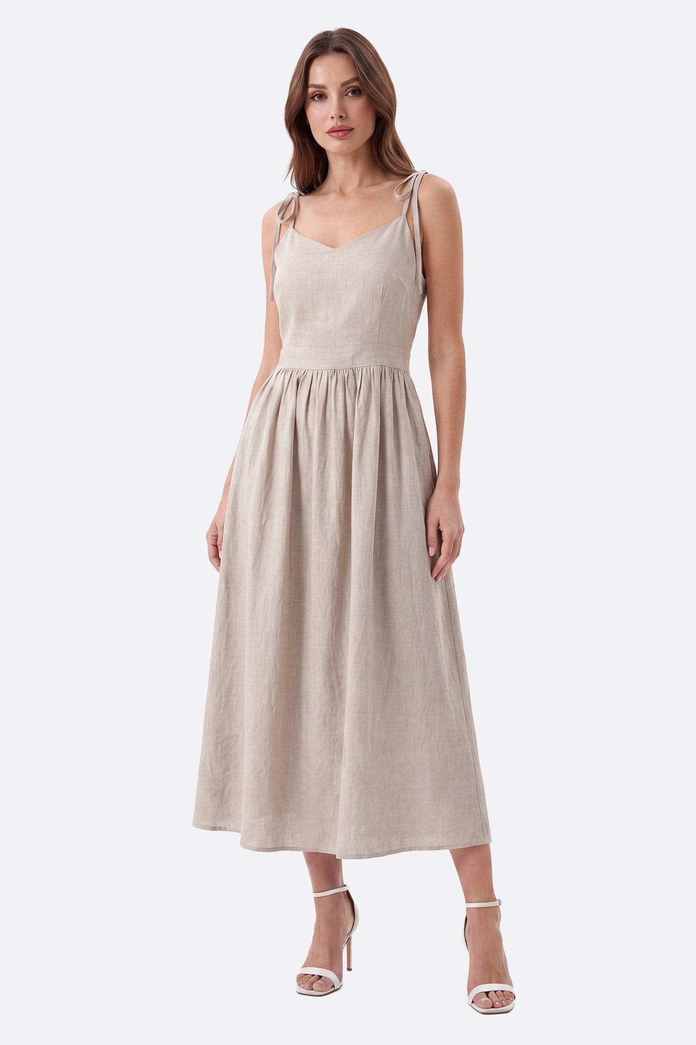Robe midi beige portée de face, bretelles nouées et décolleté en V, jupe plissée