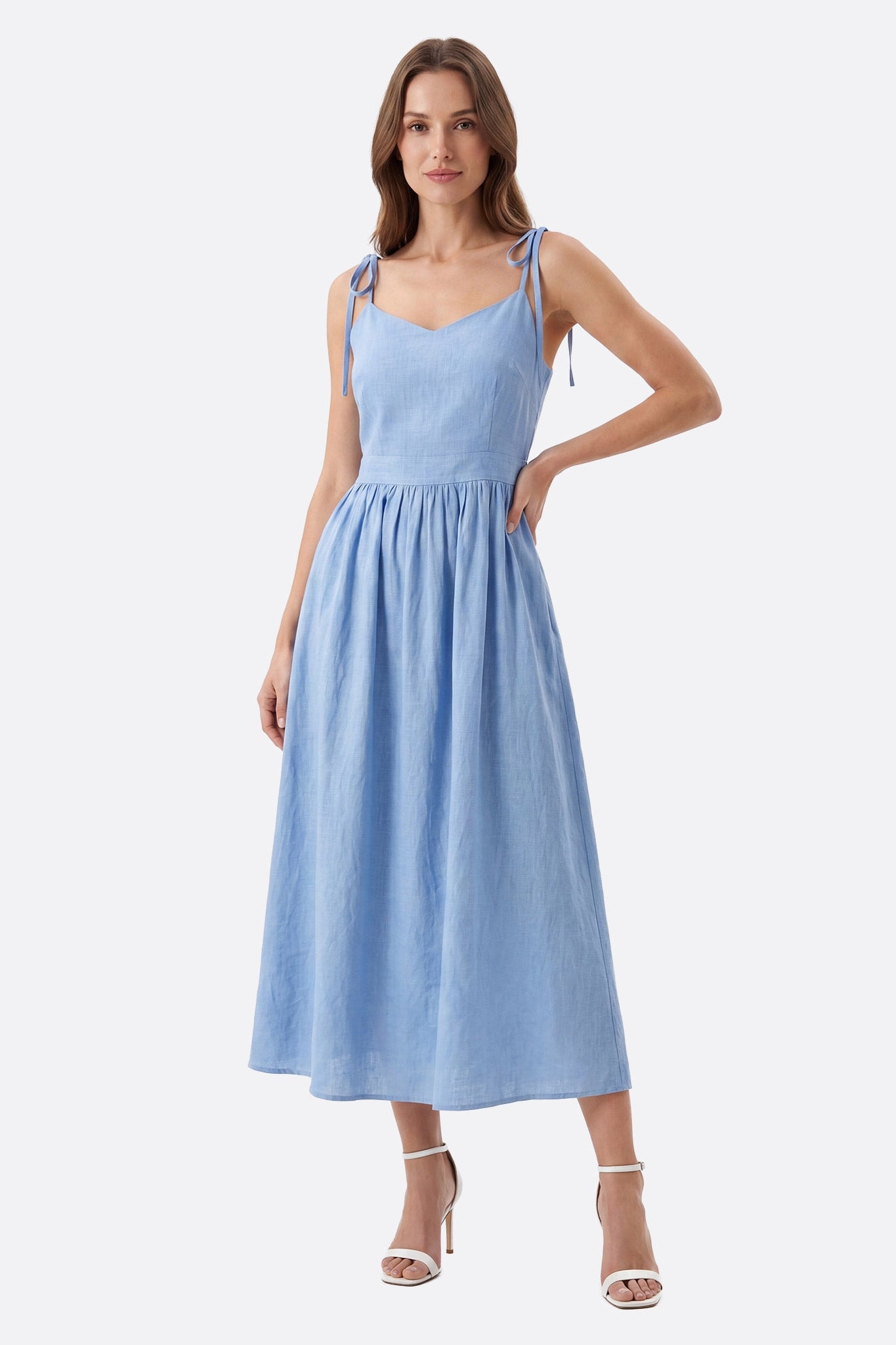 Modella frontale in abito midi azzurro cielo con spalline annodate e vita segnata