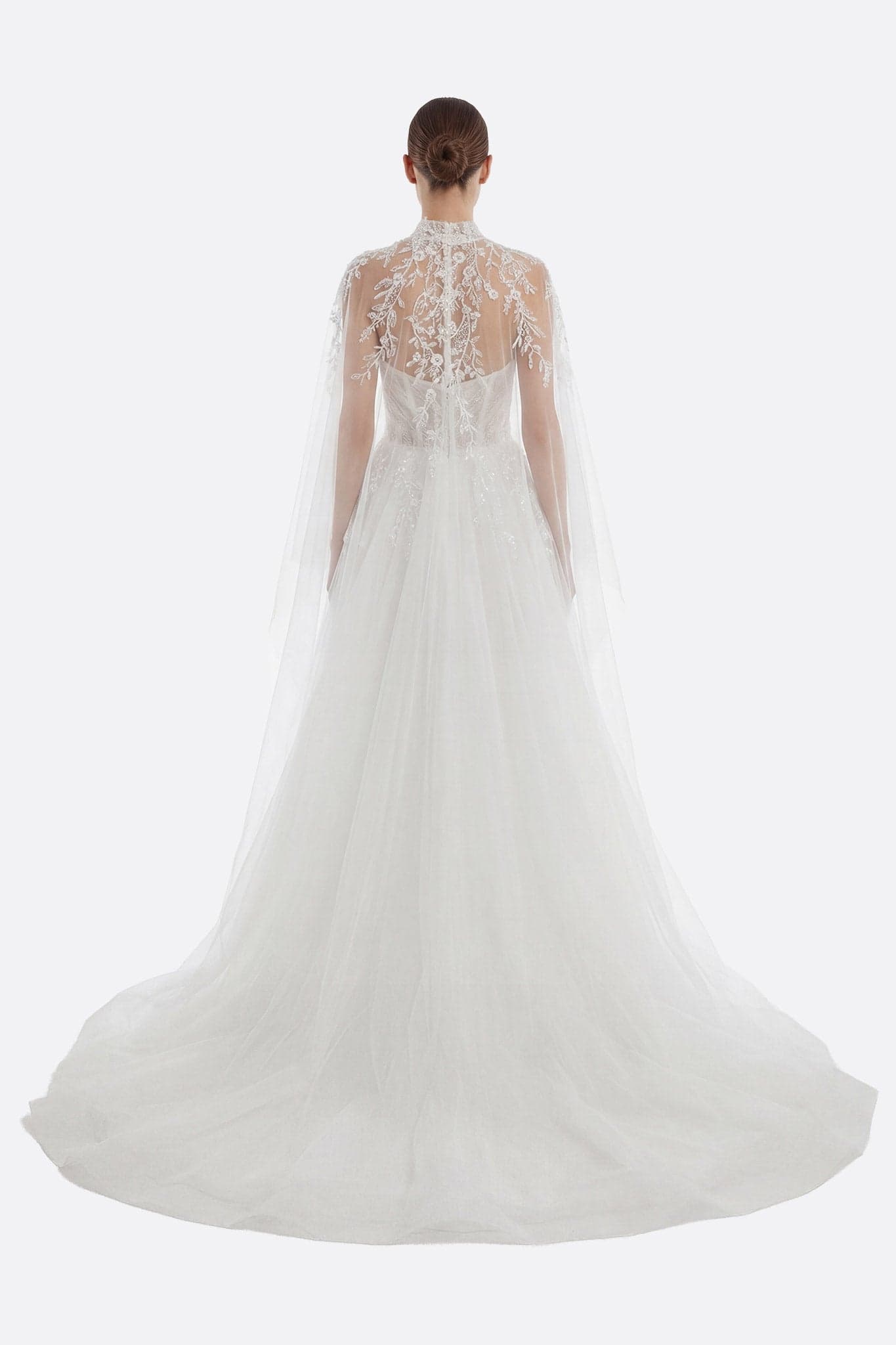 Vista ravvicinata dell'abito da sposa in tulle, mettendo in evidenza il bustier ricamato e la delicata cappa rimovibile.