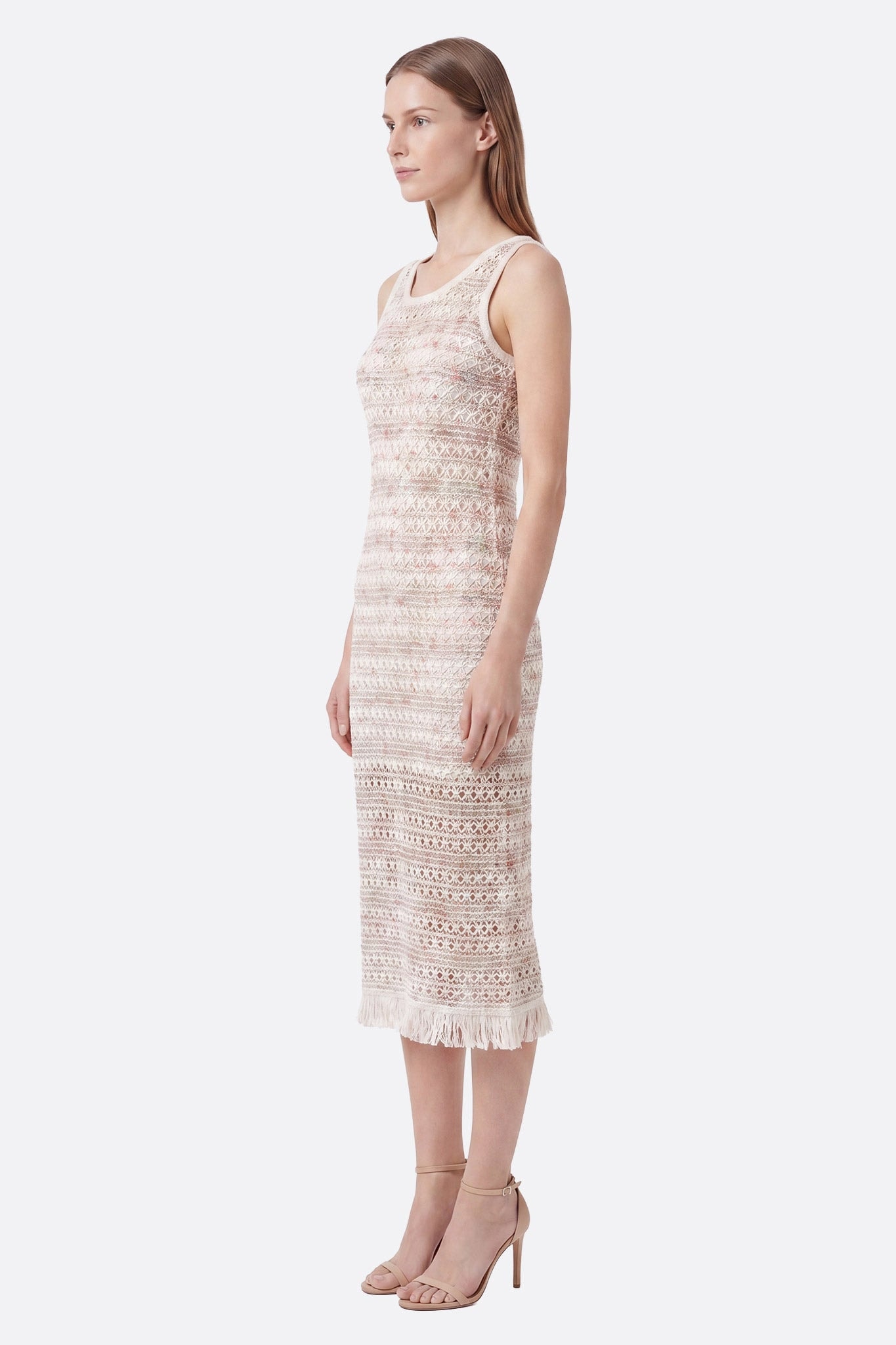 Model in profile wearing ecru textured midi dress with gradient pattern and fringe at hem