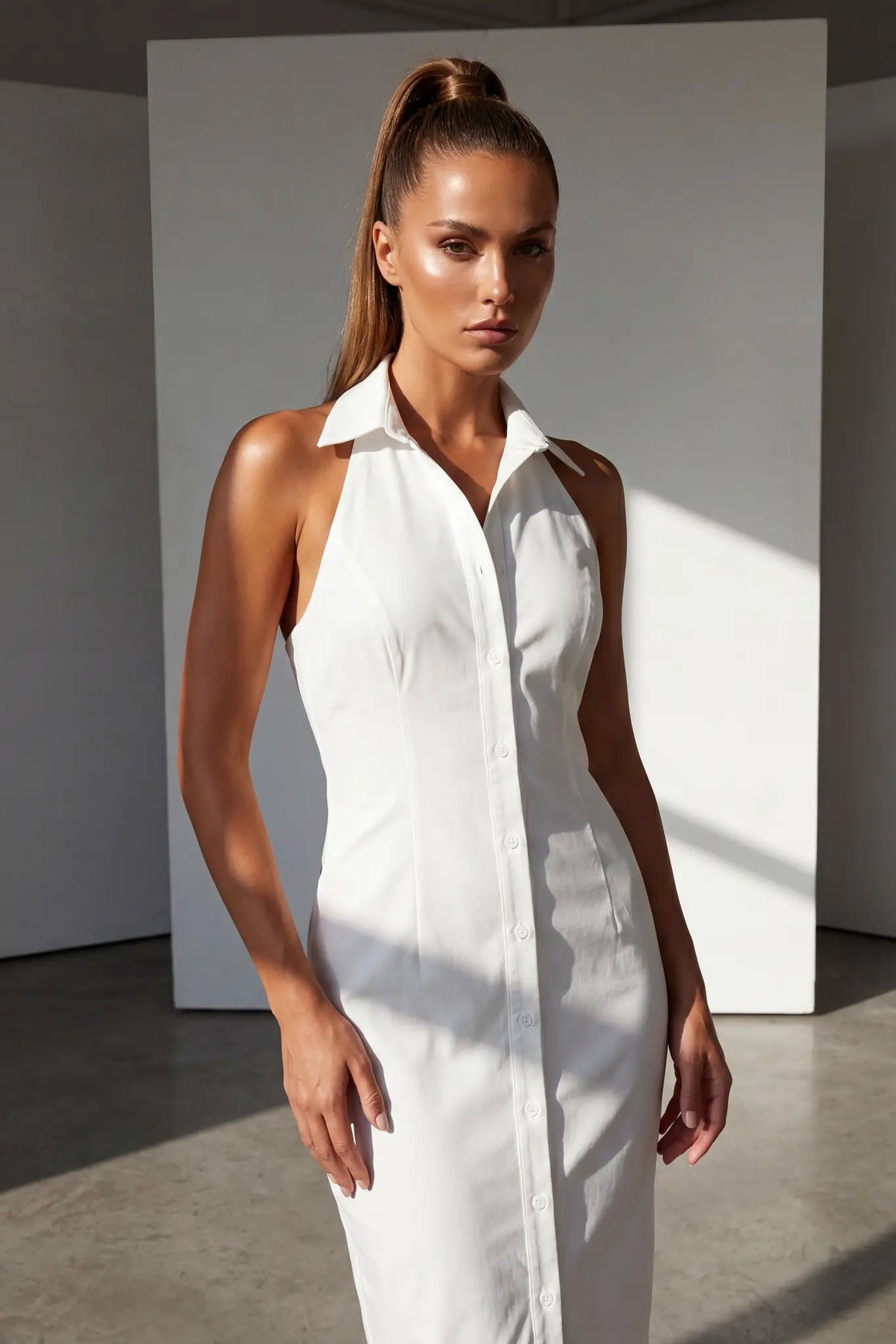 Modella frontale in abito midi bianco con colletto camicia e abbottonatura integrale, primo piano sul busto