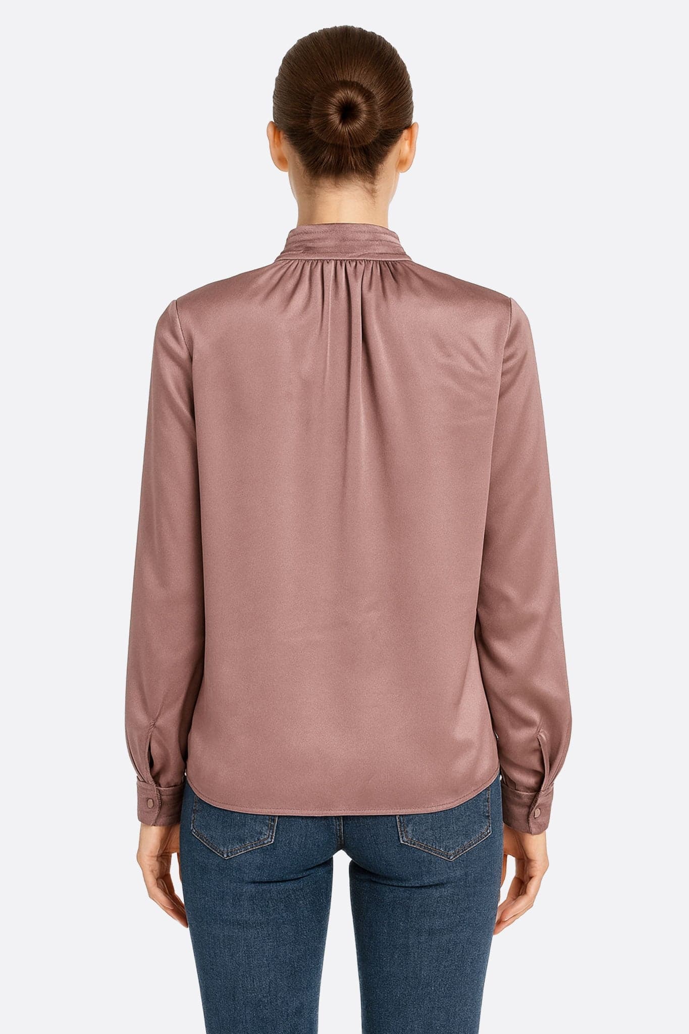 Silhouette pulita della blusa in raso rosa cipria a maniche lunghe, che rivela il suo delicato colletto rialzato ideale per una...