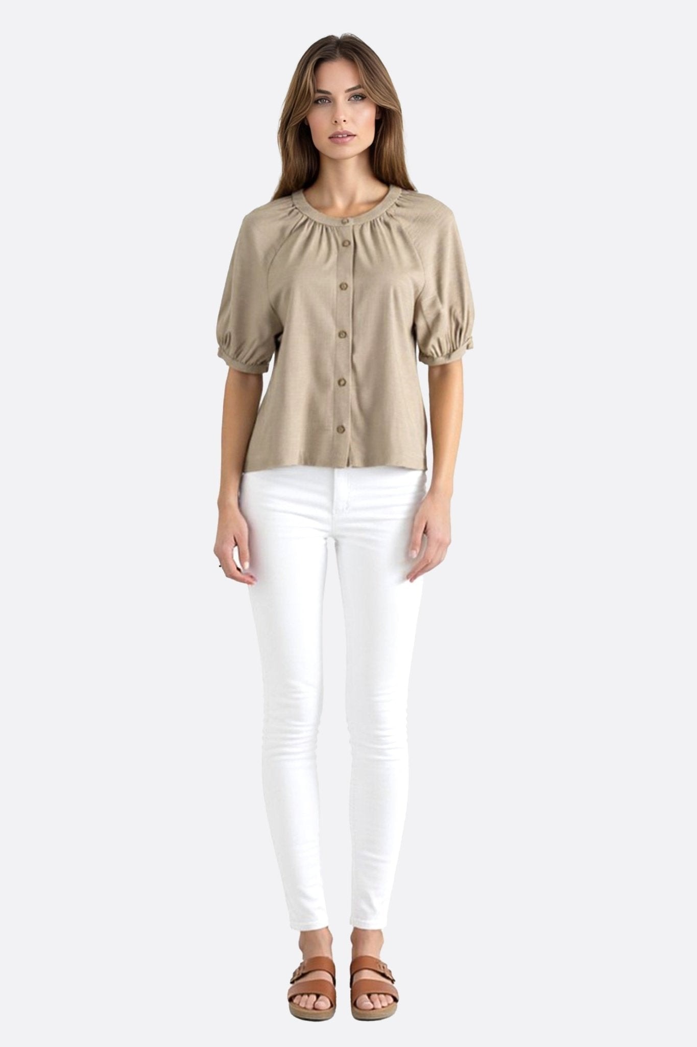 Close-up of the beige linen blouse, highlighting the airy texture and refined buttons of the short sleeves for a look...