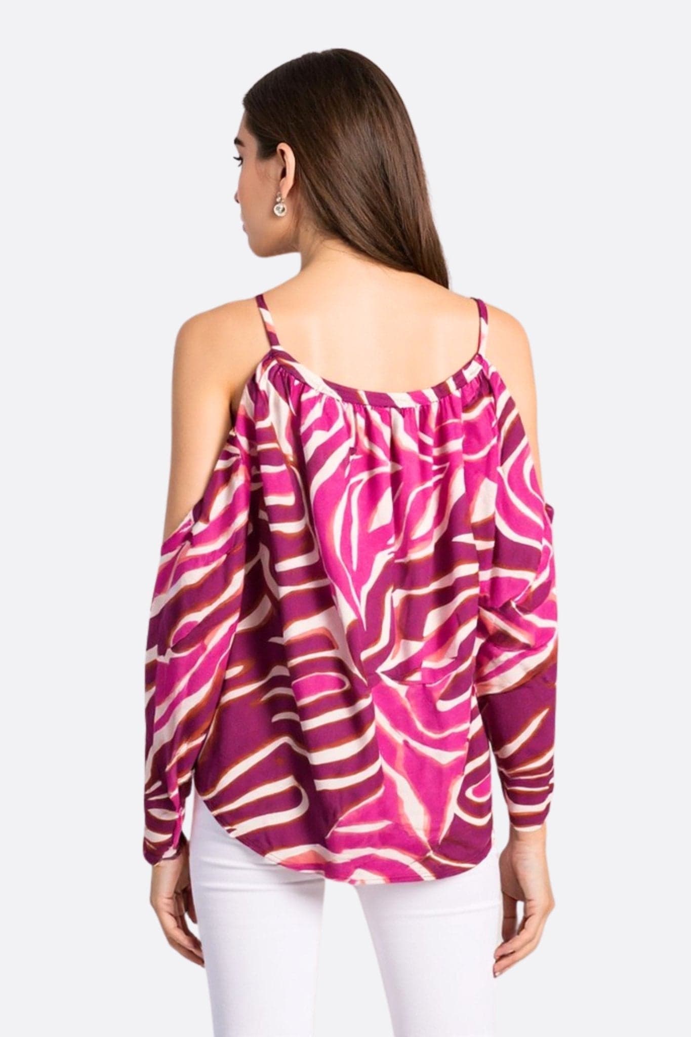 Dettaglio ravvicinato della blusa fluida fucsia con motivi zebrati, che rivela la sua texture leggera e il suo fascino audace per...