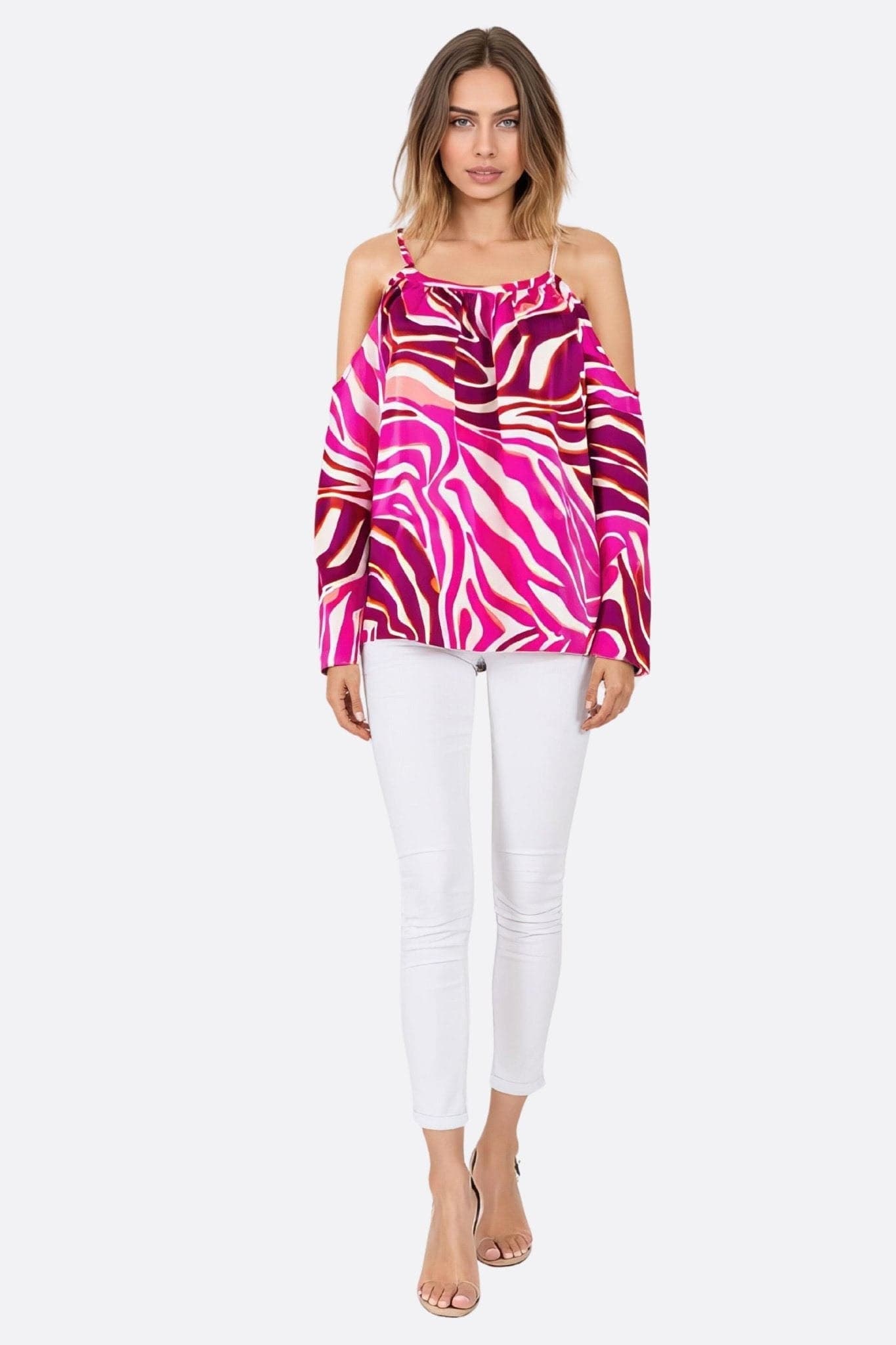 Dettaglio vibrante della blusa fluida fucsia con stampa zebrata, che sottolinea le spalle scoperte per un'eleganza raffinata.