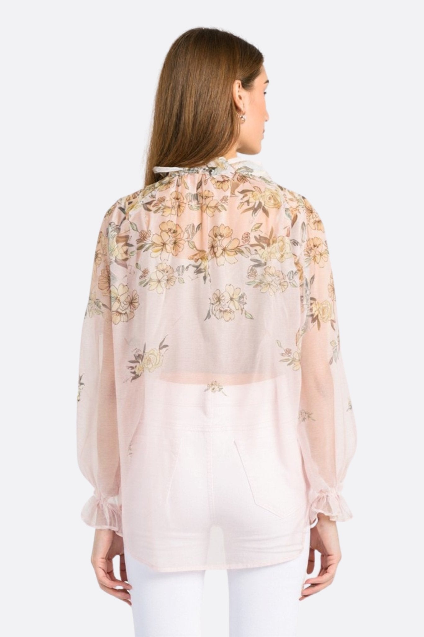 Three-quarter view of a pastel pink floral voile blouse, elegantly light, perfect for a summer dinner.