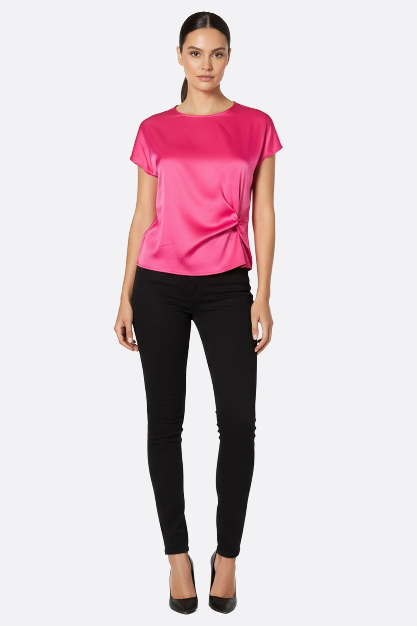Primo piano delle delicate arricciature della blusa fucsia in raso, che offrono un tocco raffinato e luminoso per occasioni...