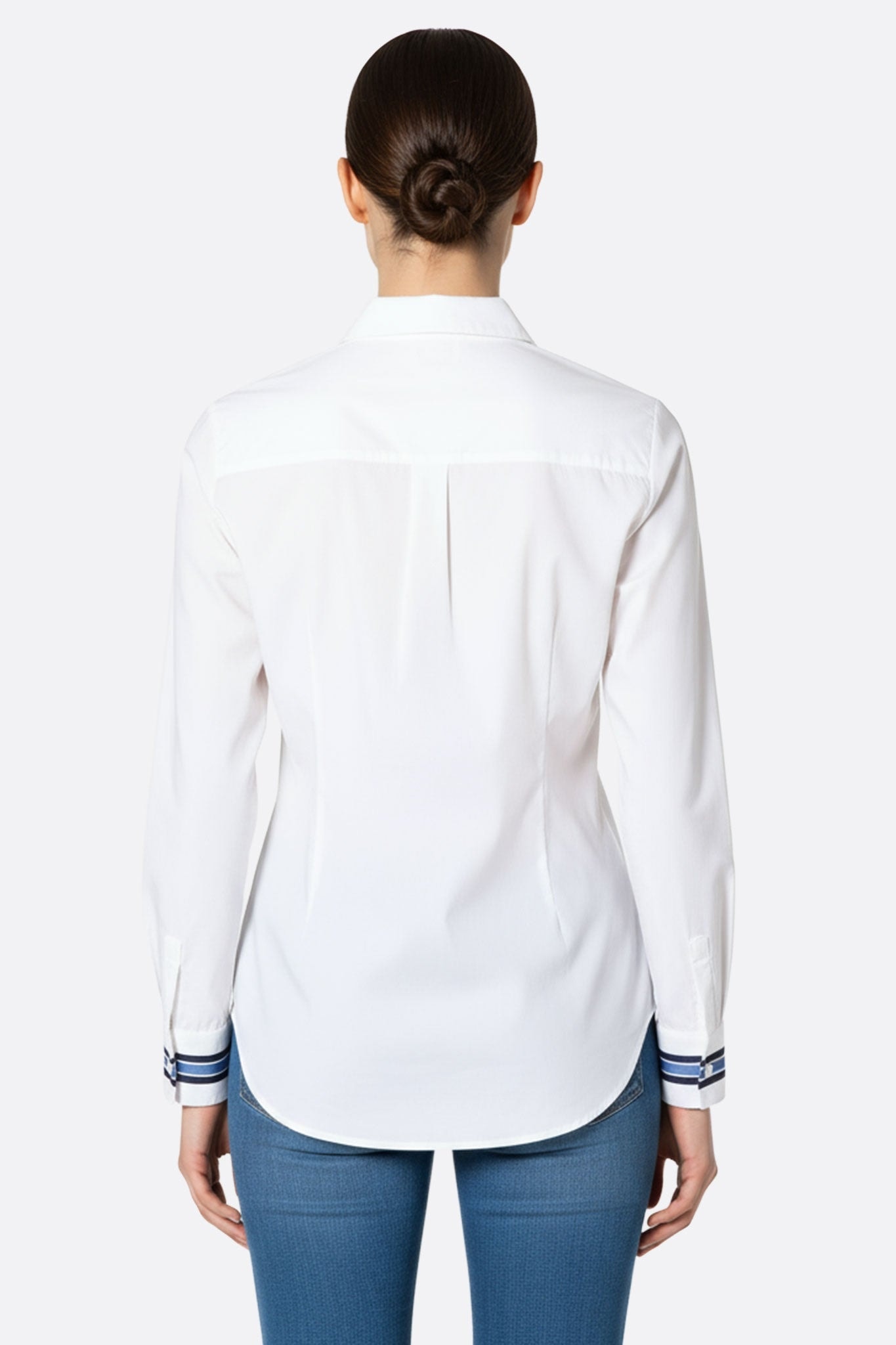 Zoom sur les poignets rayés de la chemise blanche cintrée, un détail élégant pour un look chic et intemporel.