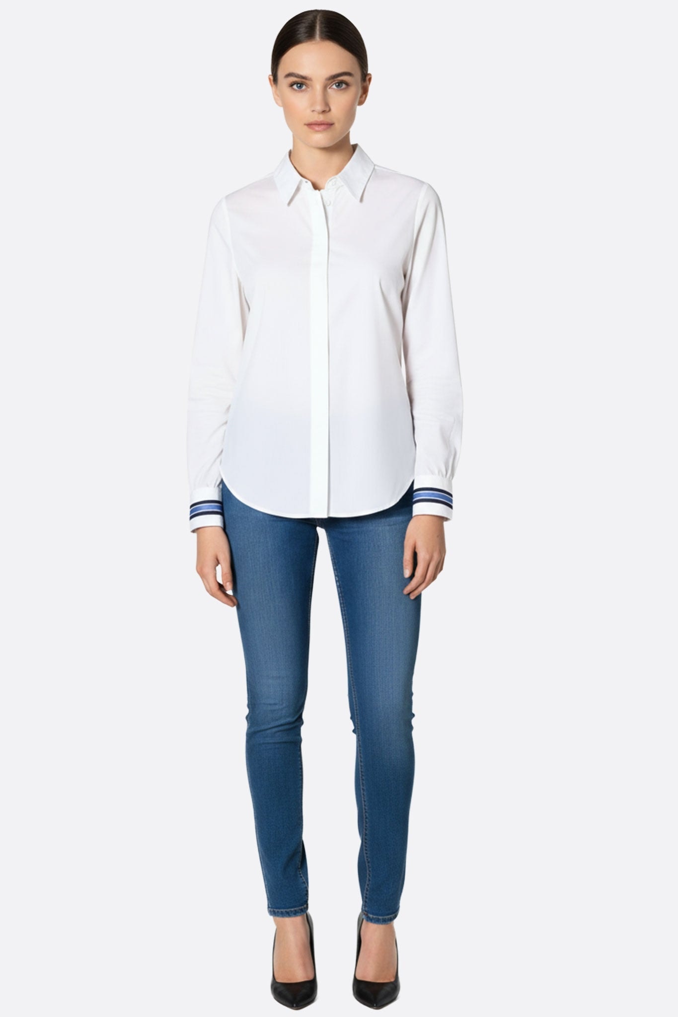 Perspective sur la chemise blanche ajustée, mettant en avant ses poignets rayés pour une allure raffinée au quotidien.