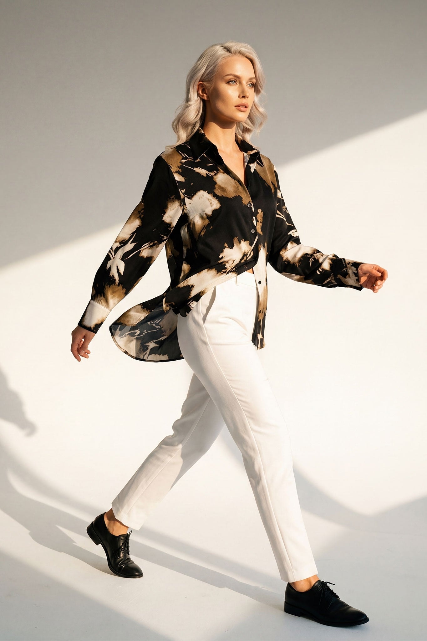 Dettaglio artistico della schiena della camicia fluida nera in viscosa, stampa astratta beige, perfetta per una serata chic e...