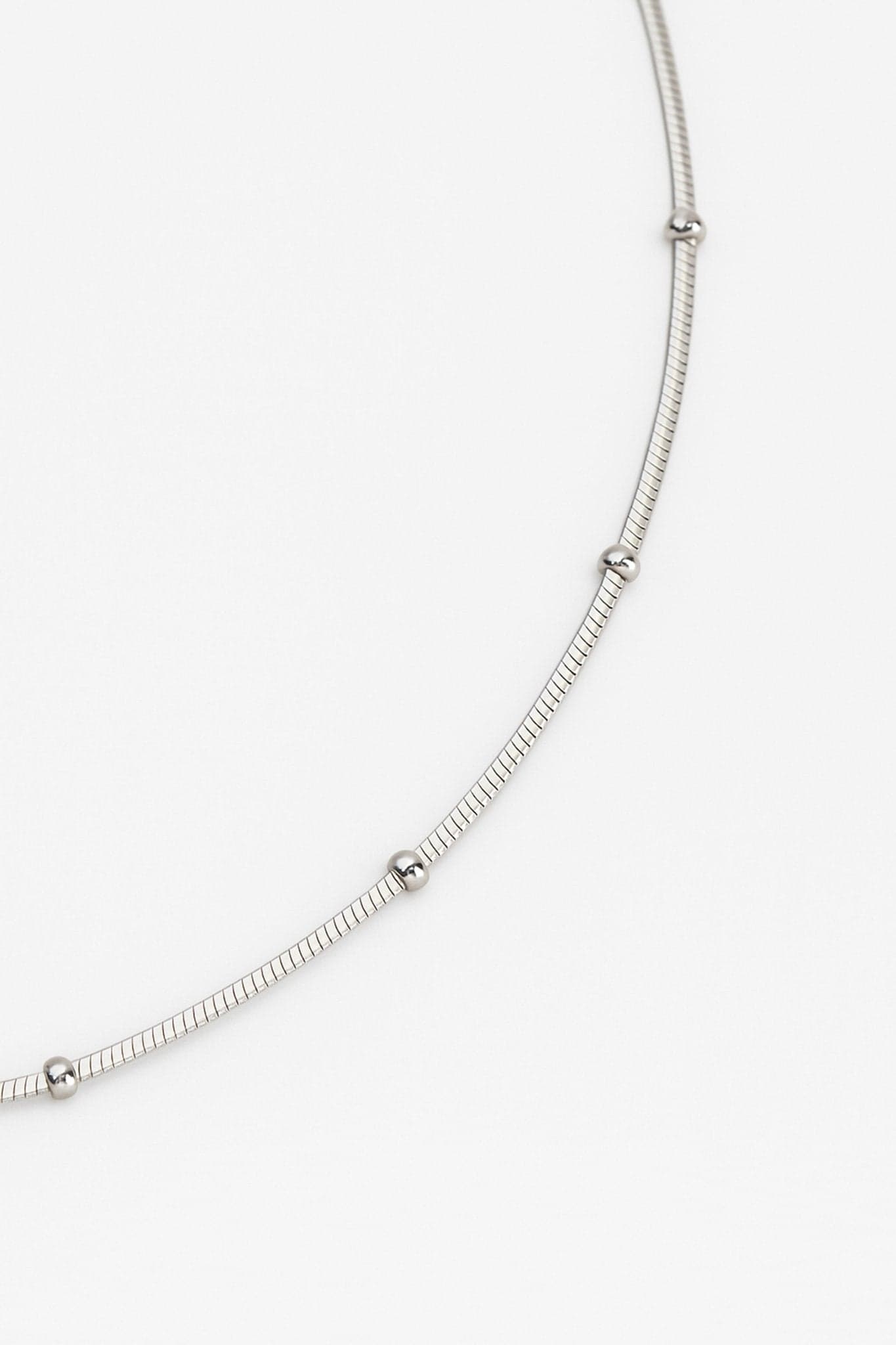Perspective alternative du collier ras-du-cou en argent 925, mettant en avant les détails raffinés des perles argentées.