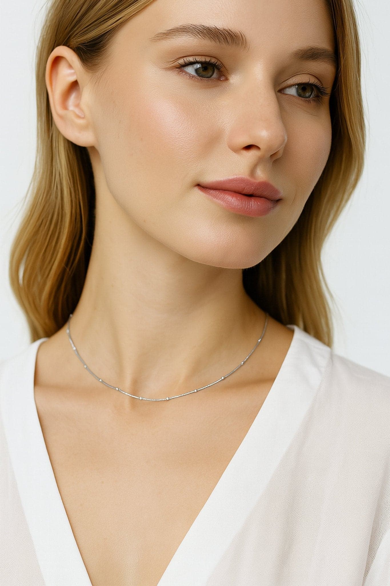 Détail du collier ras-du-cou en argent 925, mettant en lumière l'éclat des perles argentées, idéal pour une soirée raffinée.