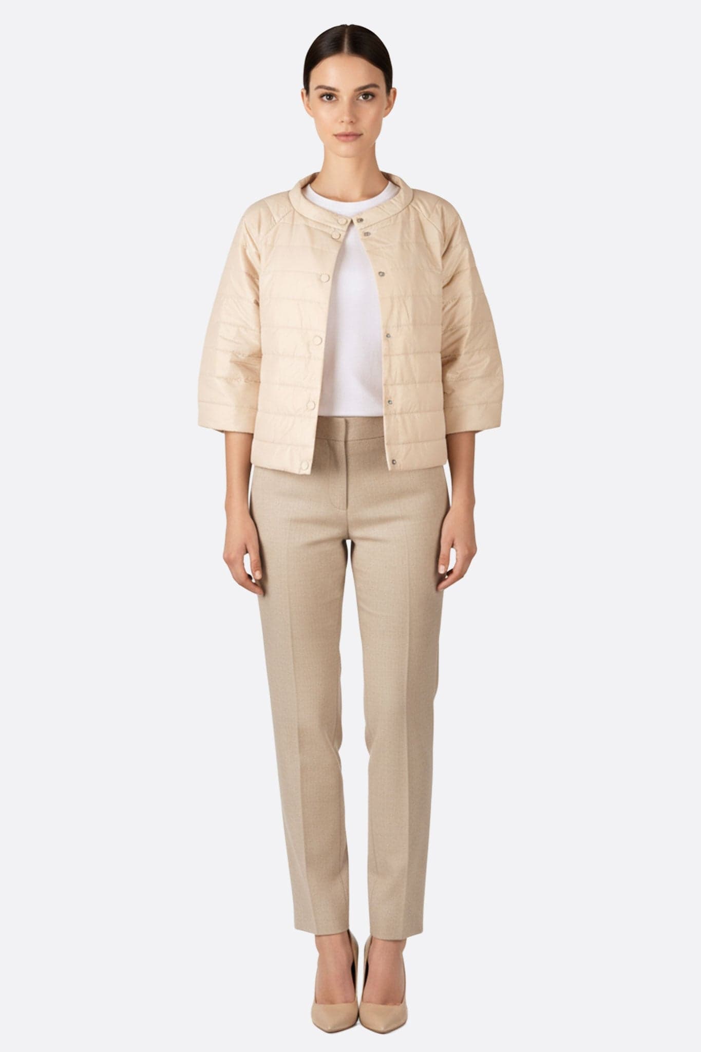 Zarte kurze beige Jacke mit 3/4 Ärmeln, die ihre seidige Textur hervorhebt, ideal für einen raffinierten urbanen Stil.