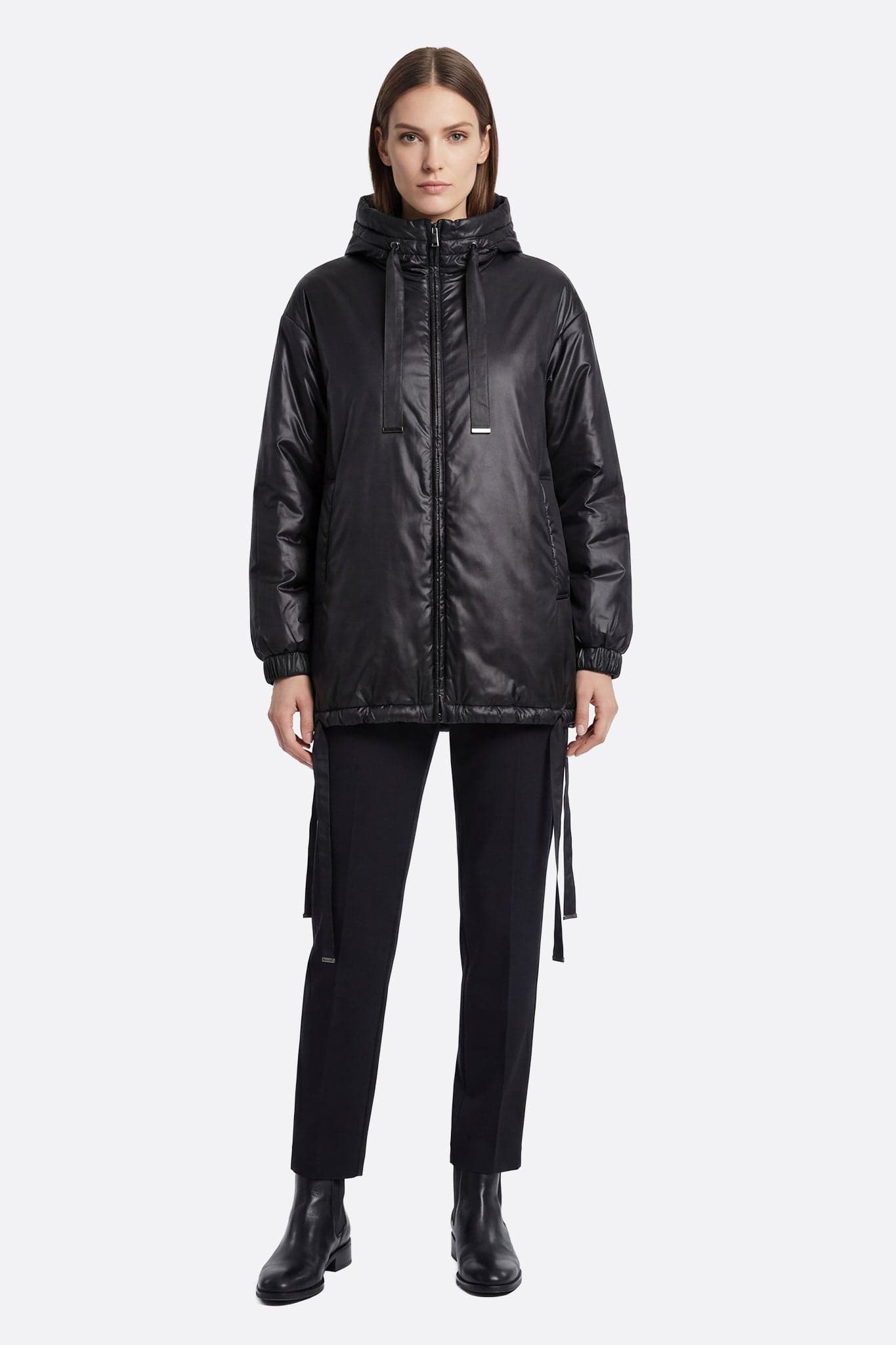Piumino nero trapuntato con cappuccio, in evidenza i dettagli raffinati e i lacci regolabili per un look elegante