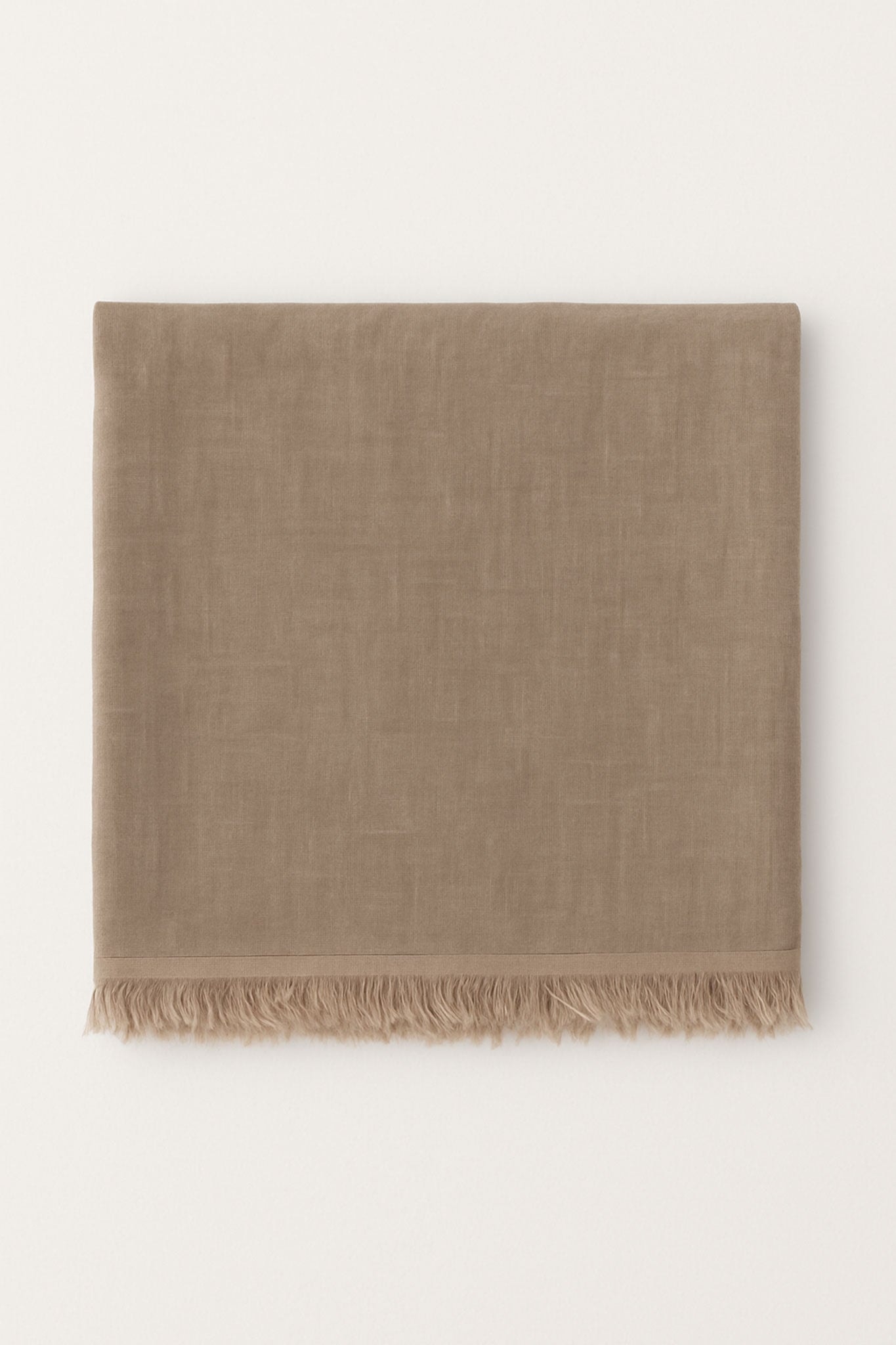 Zoom sur l'écharpe beige en tissu naturel, mélange subtil de modal et cachemire, pour une allure raffinée et chaleureuse.